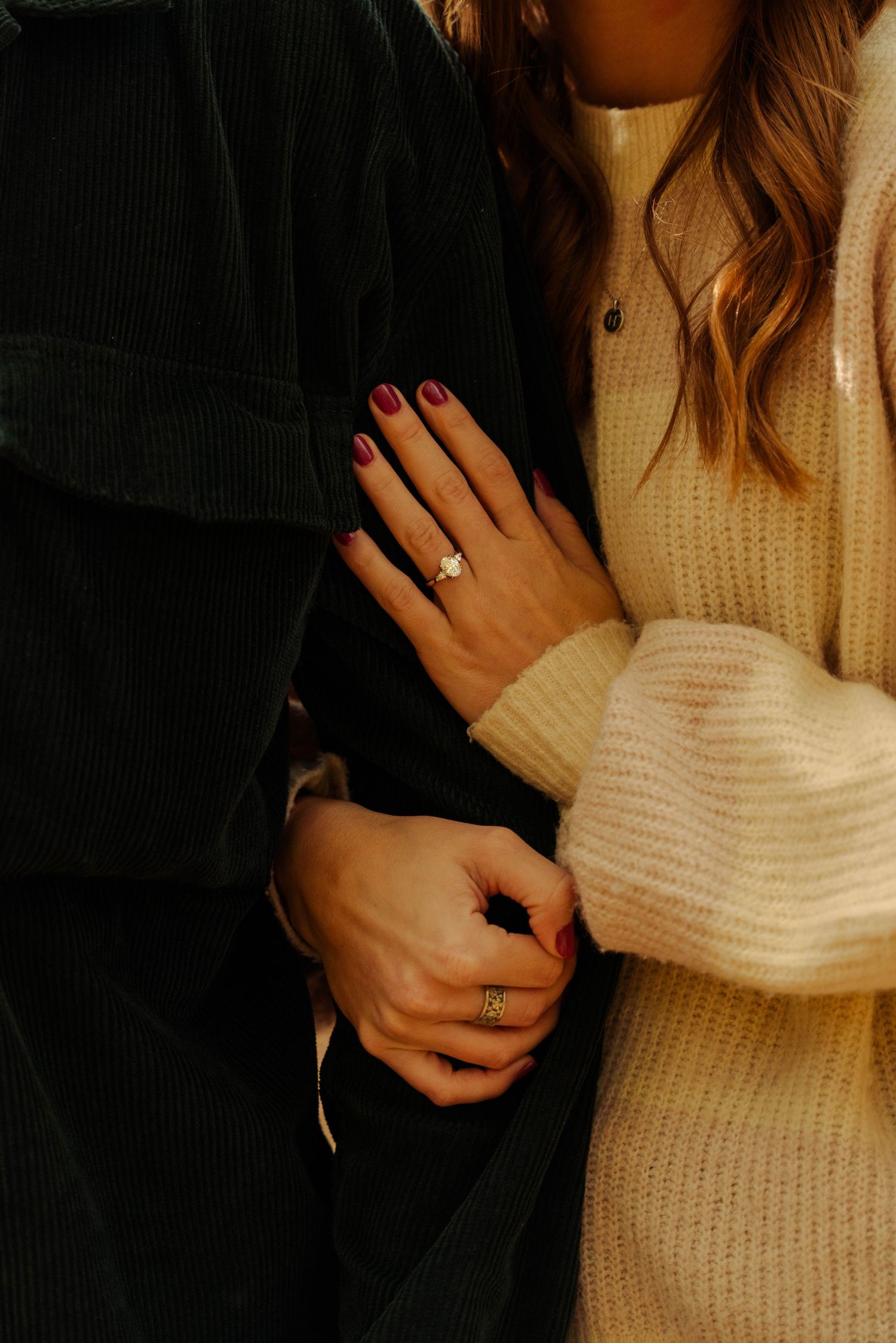 Close-up of hands and sweater details during an intimate couple's moment.