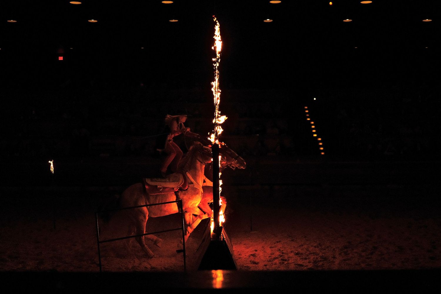 A large bonfire blazes in the dark night, casting a warm glow on the surrounding area.