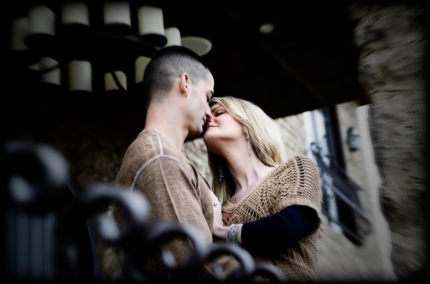engagement photo of a couple about to kiss on a balcony