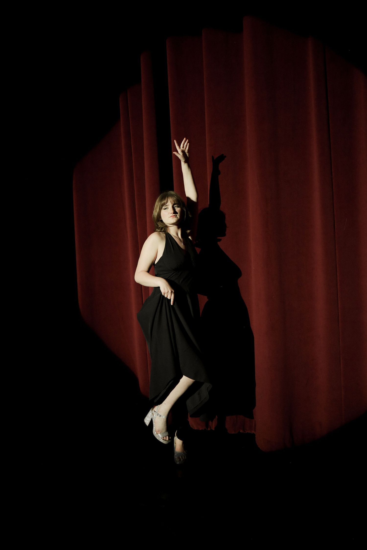 A dramatic dance performance silhouette against a red stage curtain shows graceful movements in a sequence.