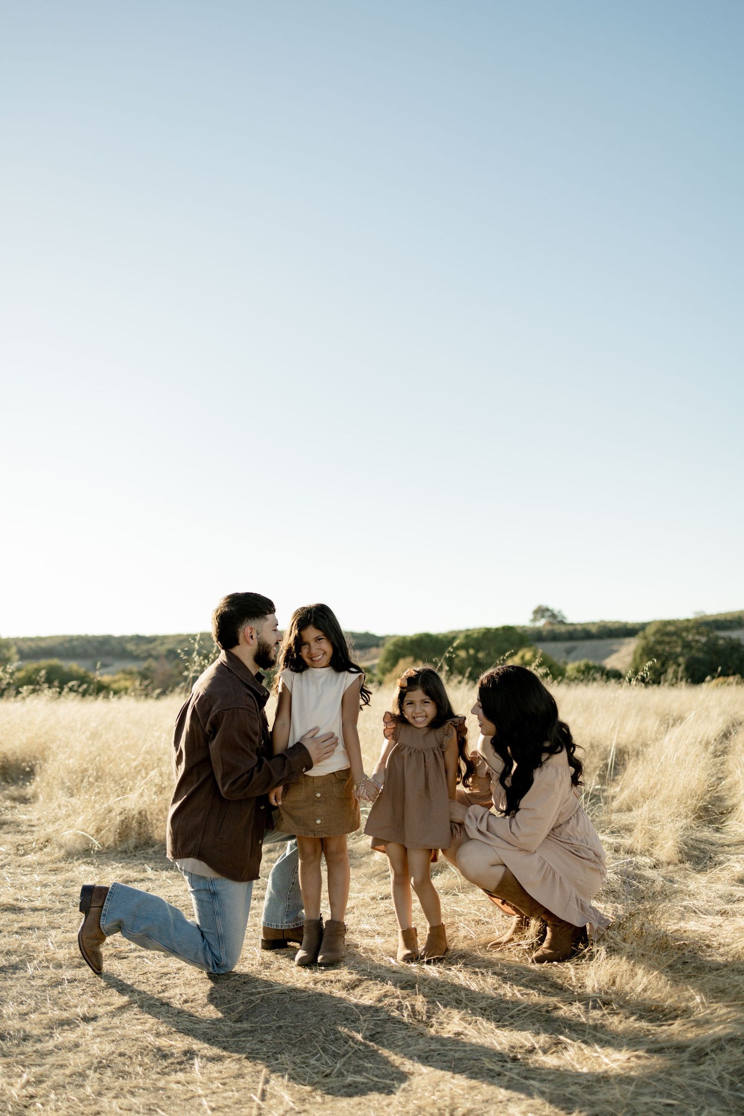 A group enjoying a sunny day together in a golden wheat field at sunset.