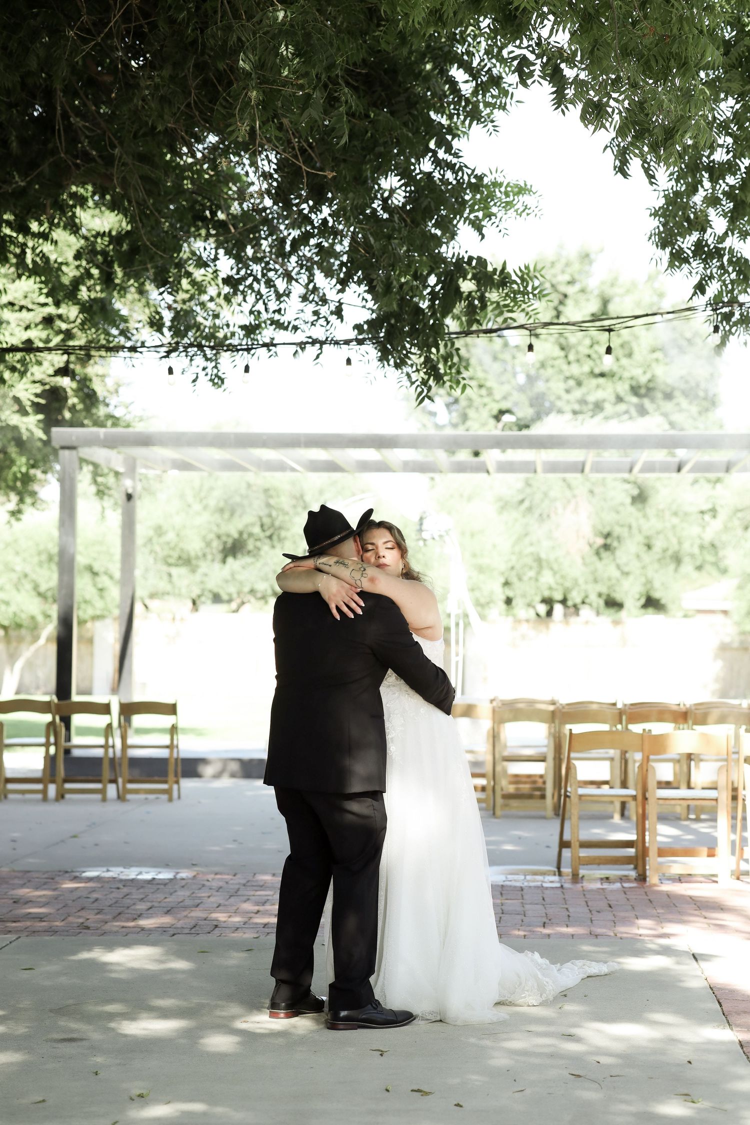 A series of romantic wedding photos showing a couple embracing under a covered outdoor venue with wooden chairs.