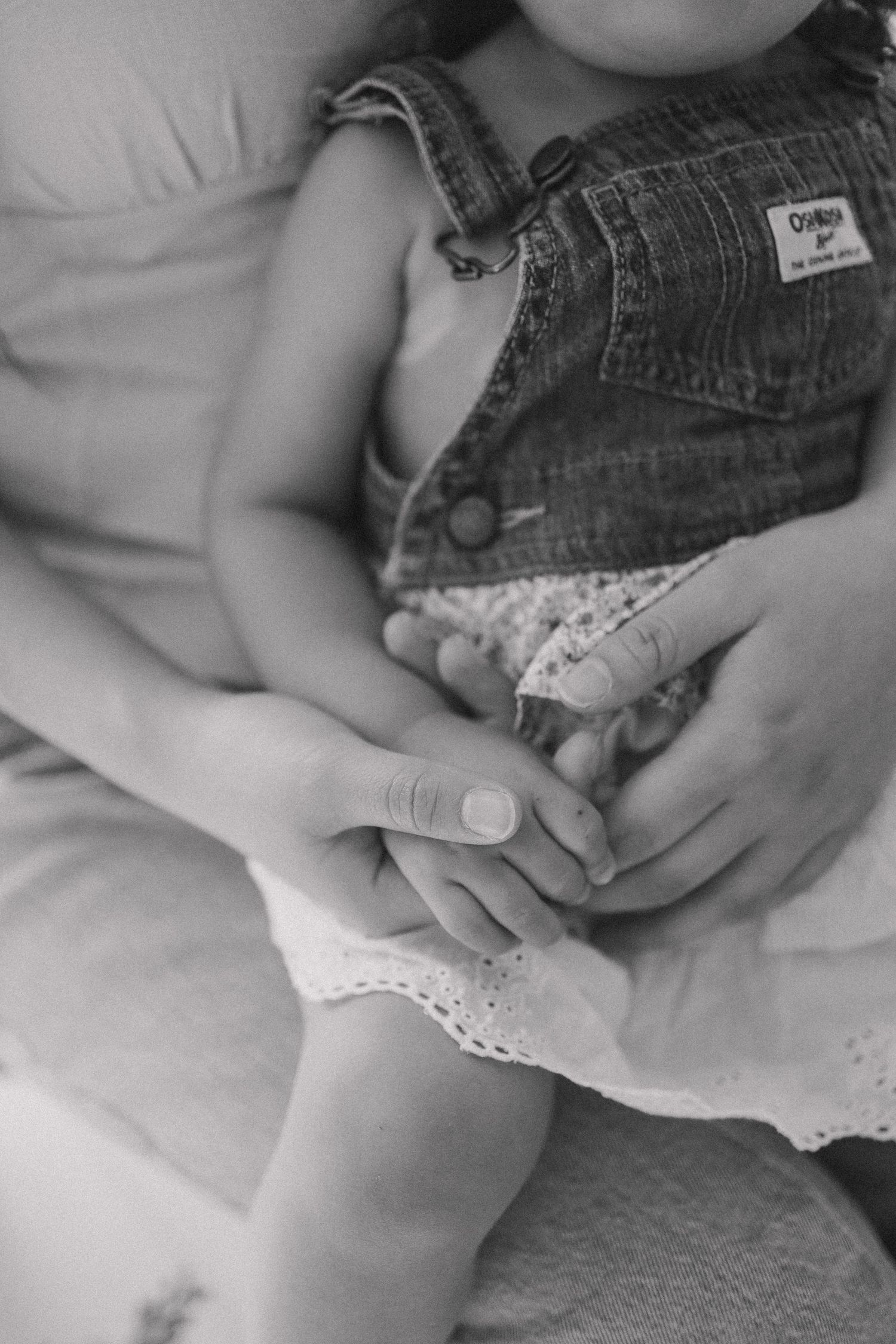 Close-up of hands gently holding delicate lace fabric against white background.