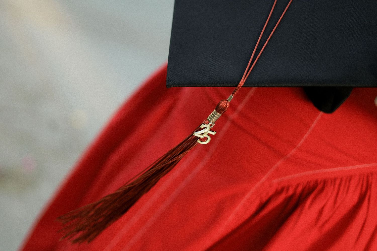 Red dress fabric with zipper detail being sewn on industrial sewing machine.