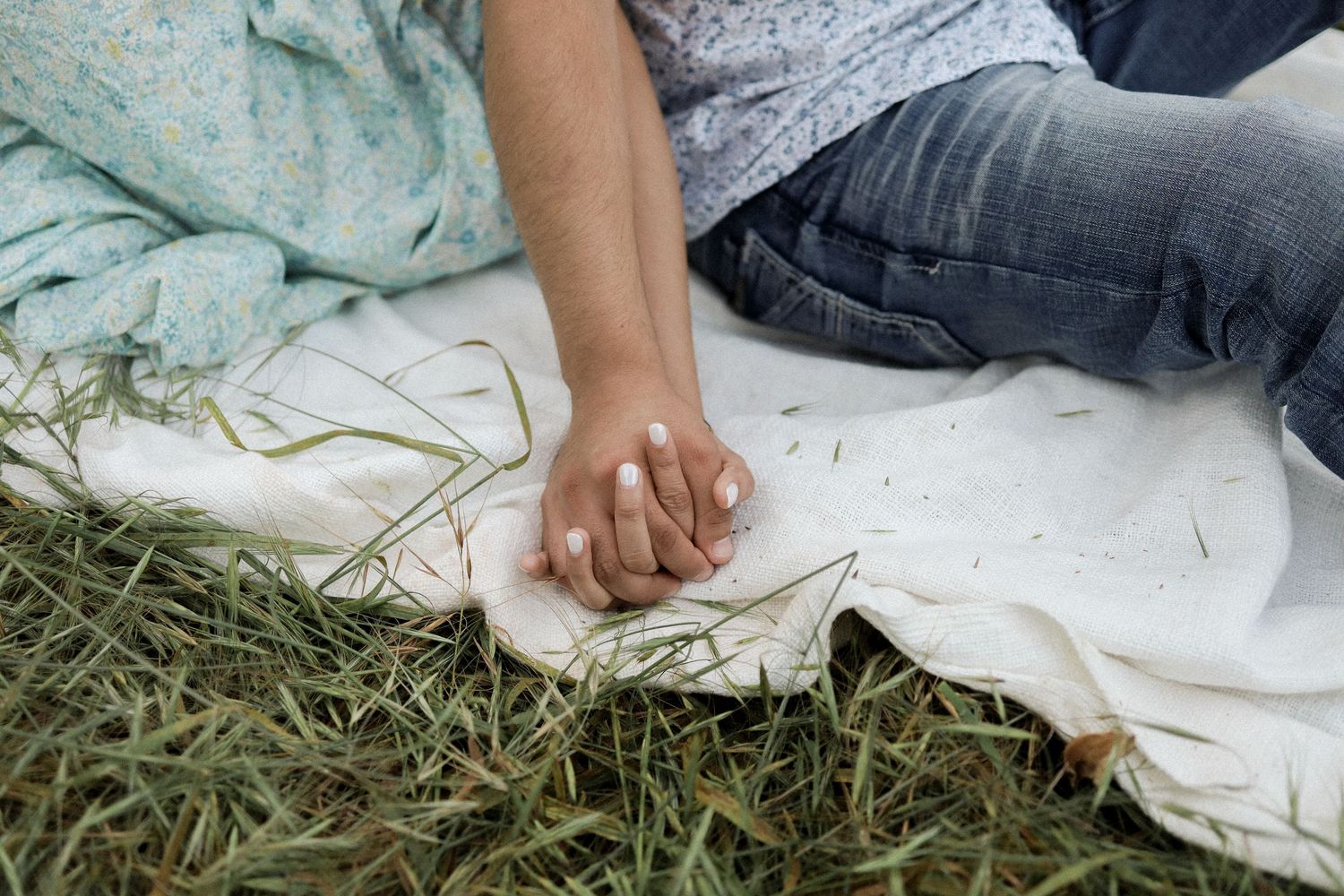 Close-up details of hands and fabric against a natural outdoor background.