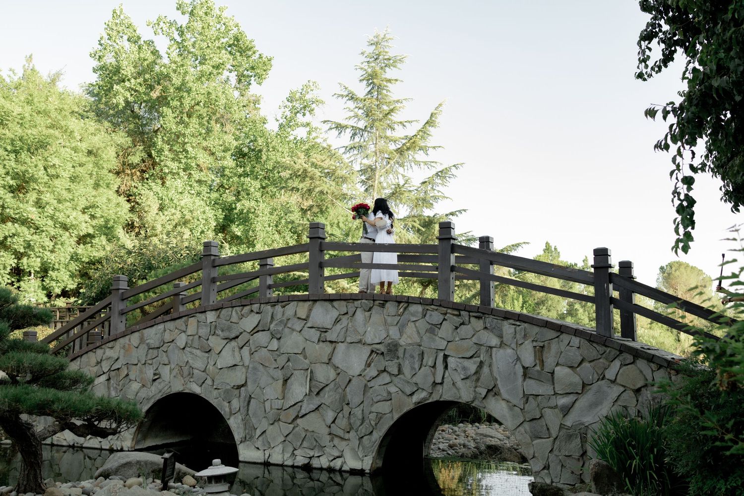 Series of stone bridge views in a lush green park setting.
