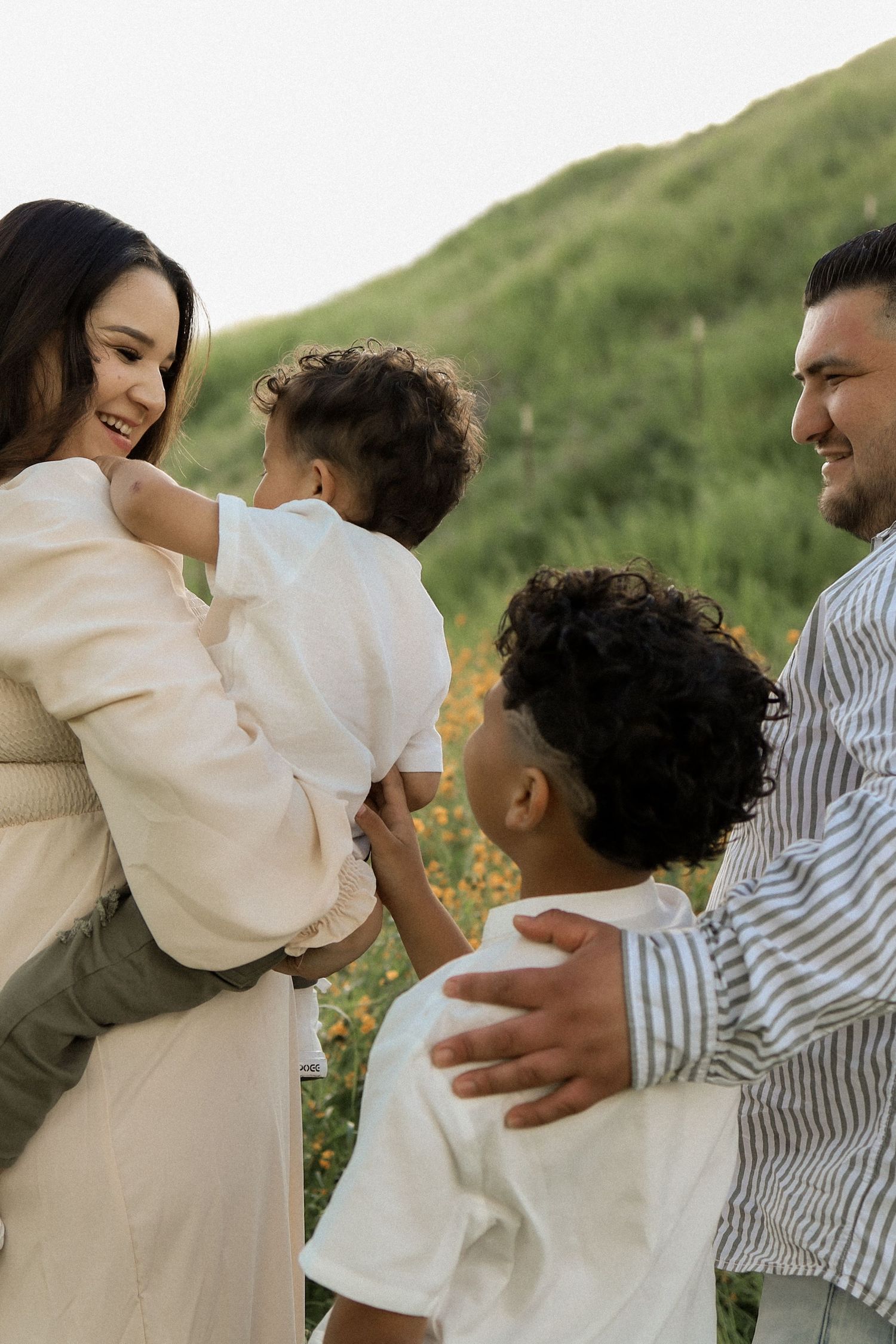 A series of candid family photos showing joyful embraces against a natural outdoor backdrop.