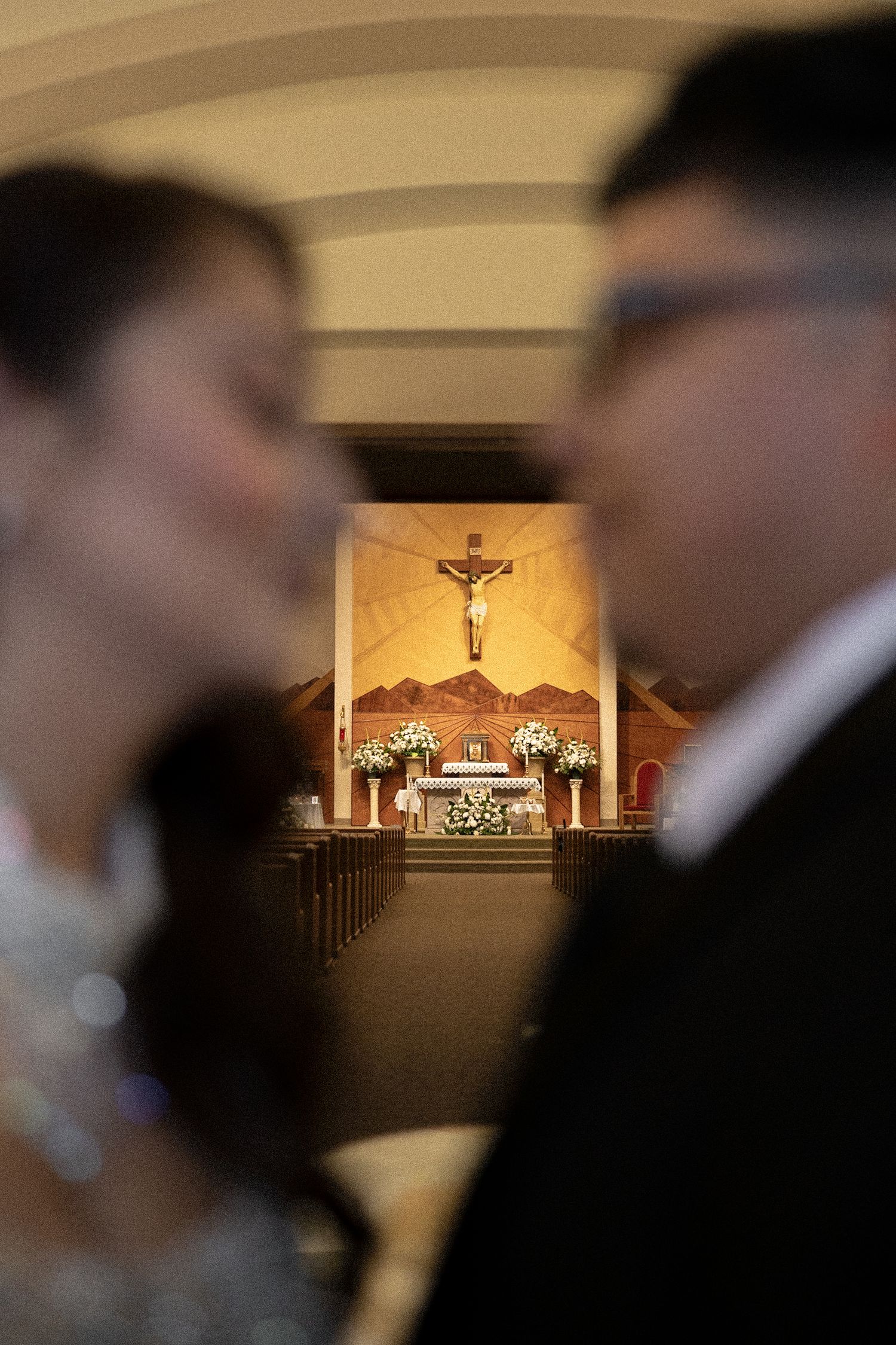 Church altar with crucifix and candles captured through artistic selective focus.