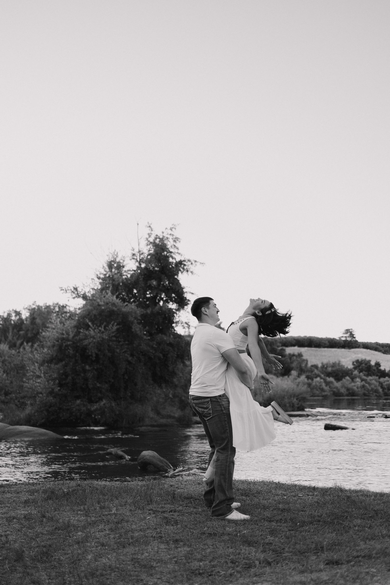 A playful sequence of silhouettes shows a couple dipping and dancing together by a lake at sunset.
