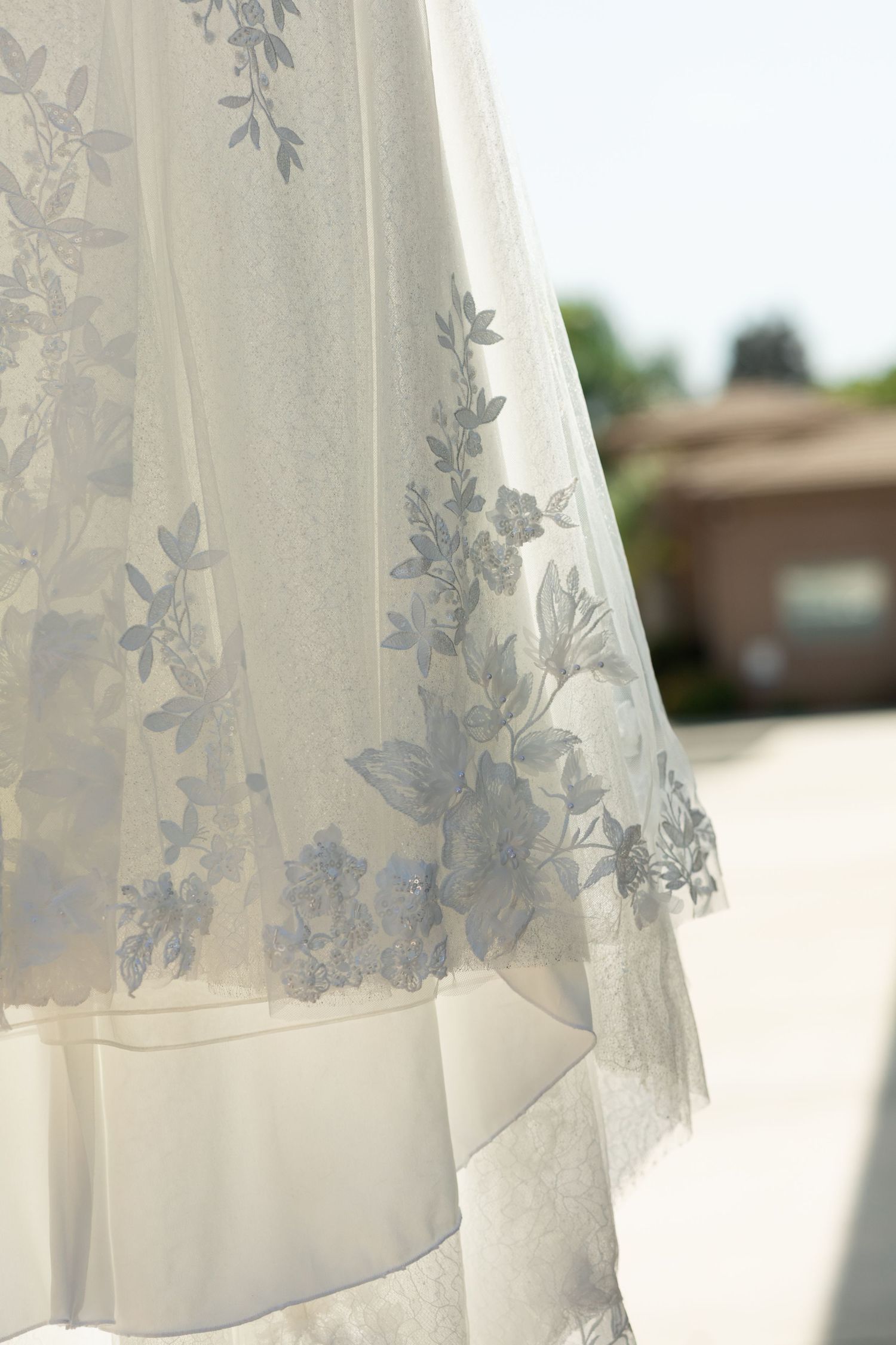 Delicate lace wedding veil with floral embroidery detail captured in soft natural lighting.
