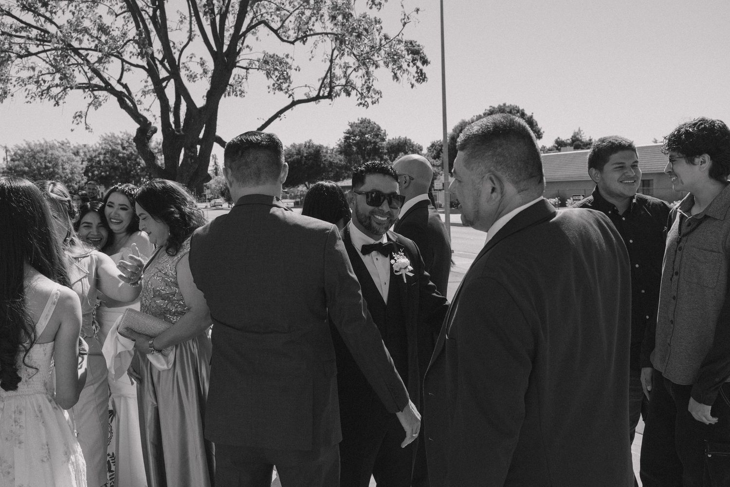 Black and white candid shots of wedding guests gathered outdoors.