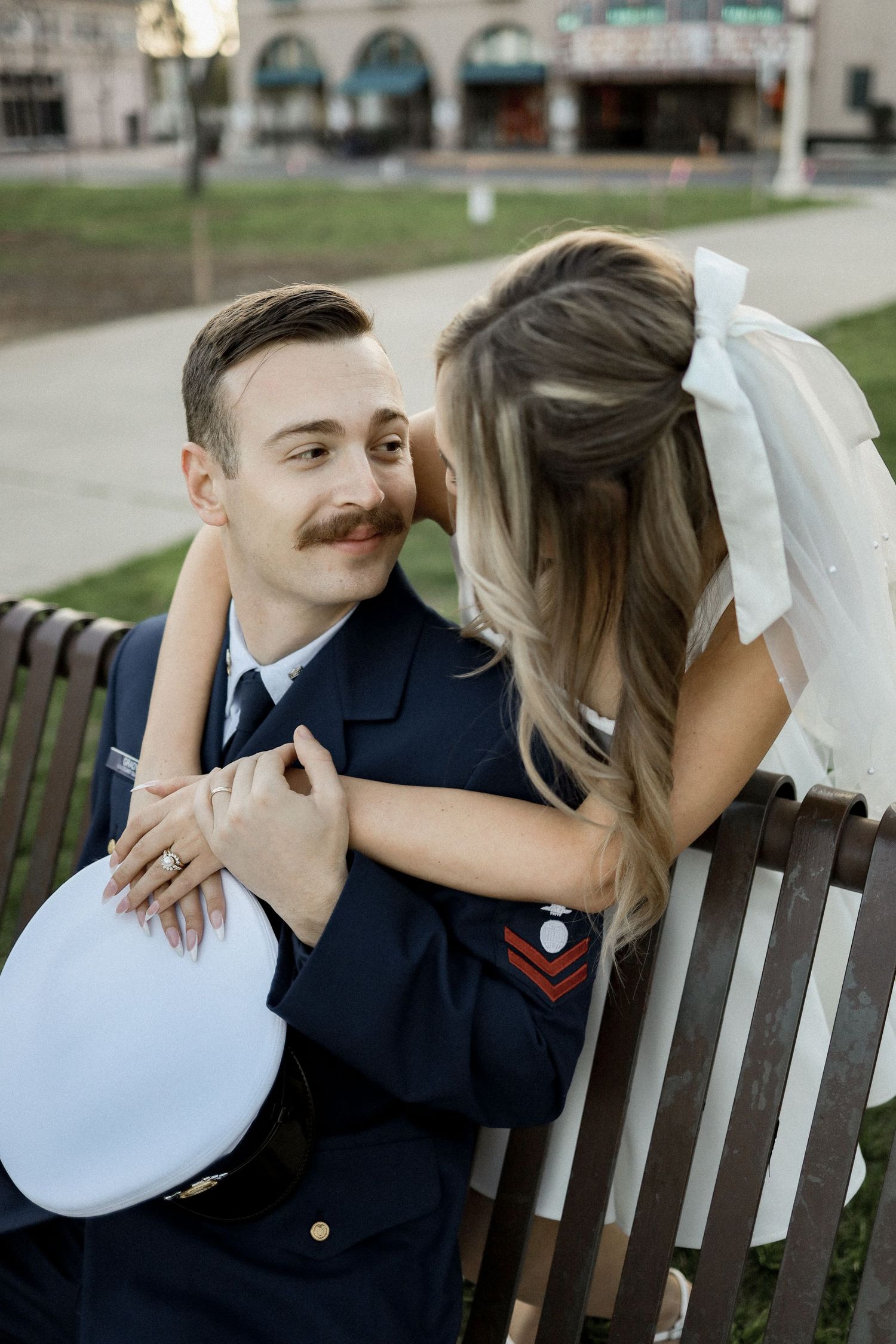 Romantic moment shared on a wooden park bench.