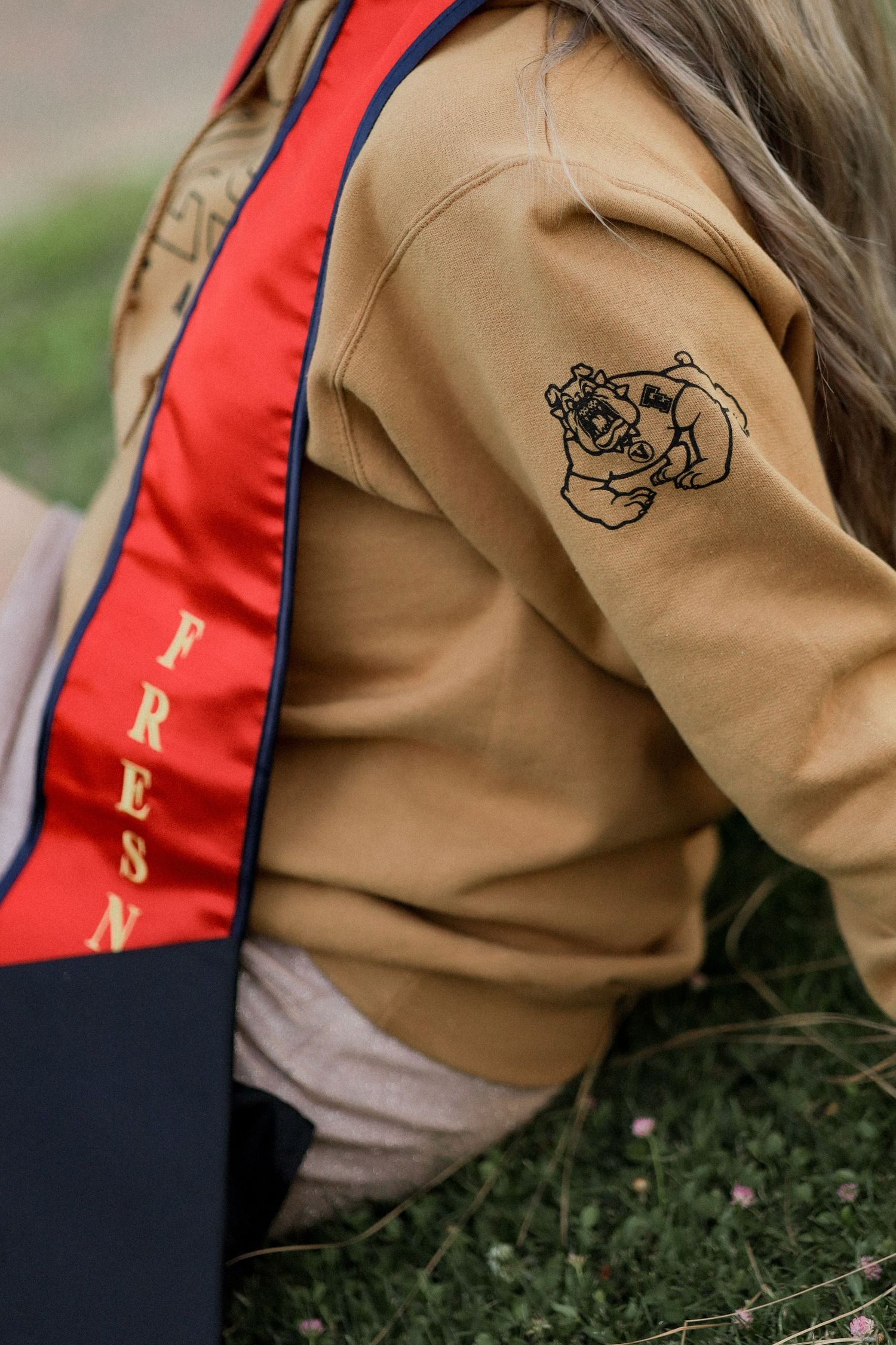 Close-up details of embroidered designs on a tan and red uniform jacket.