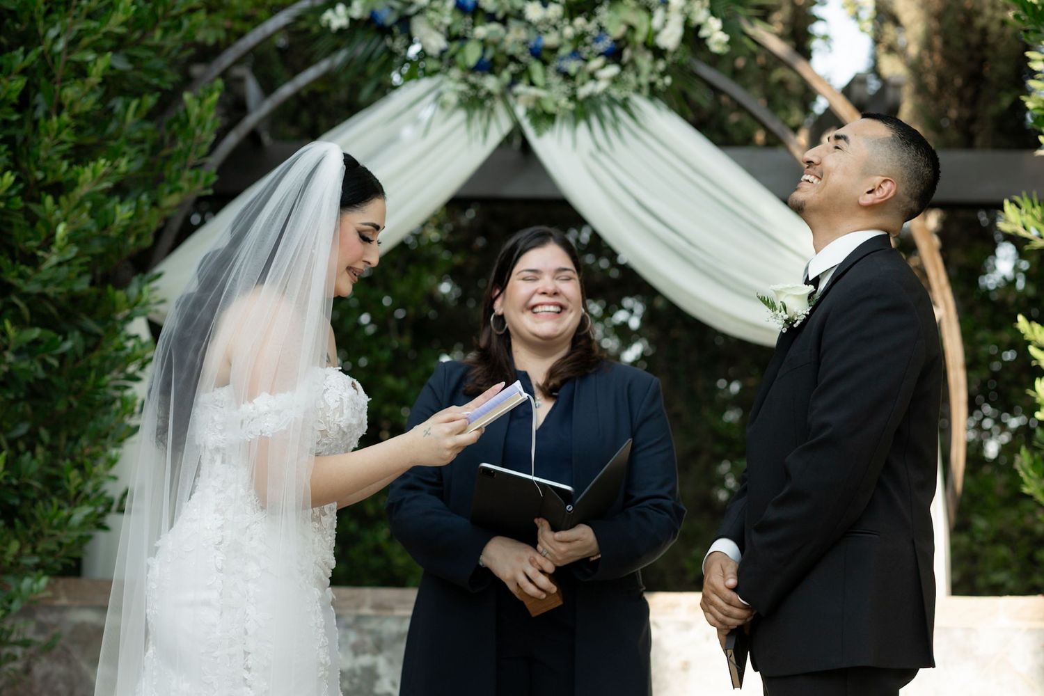 Candid moments during outdoor wedding ceremony under white draped canopy.