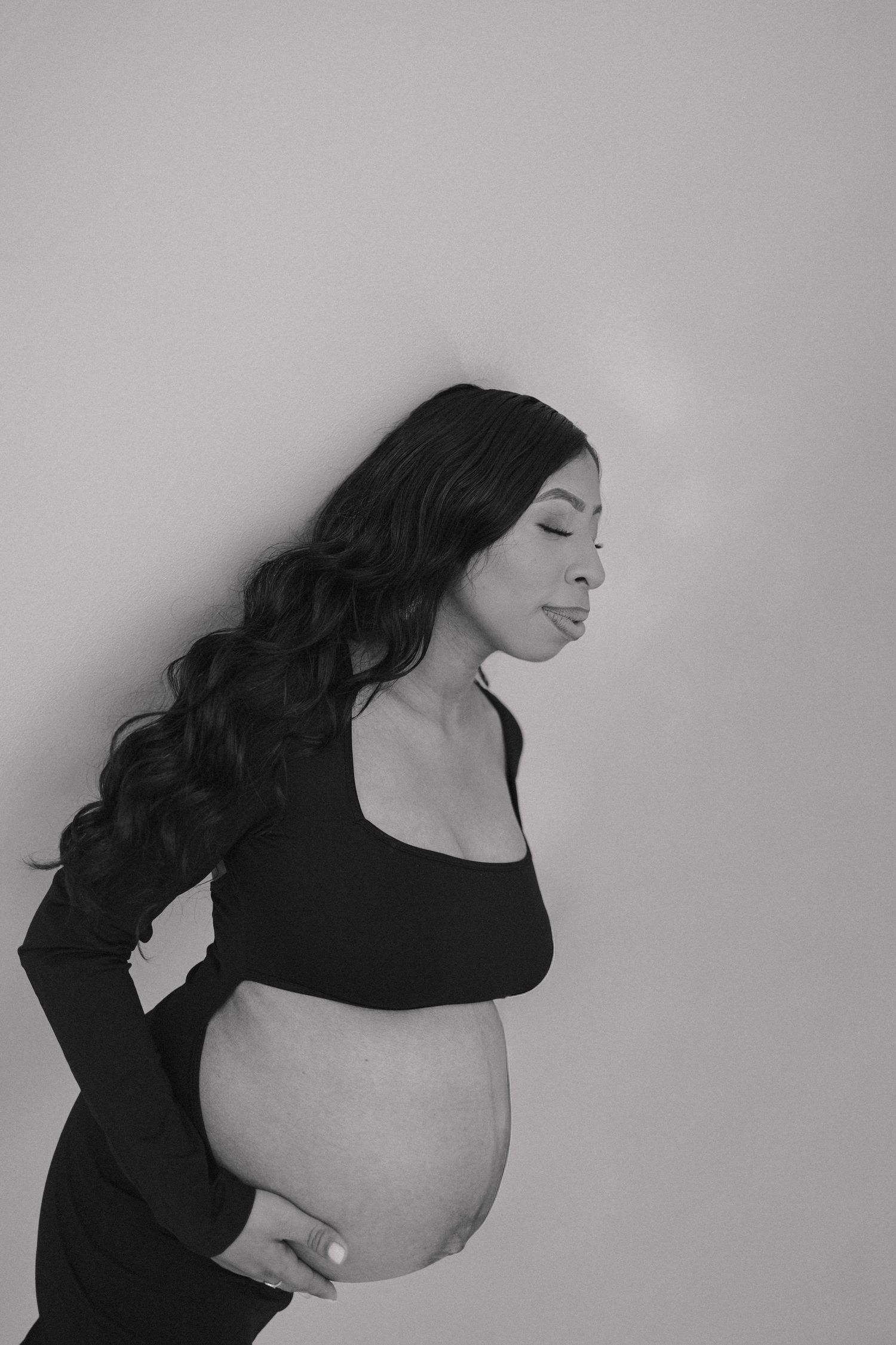 Black and white portrait series showing artistic poses with flowing dark hair against a light background.