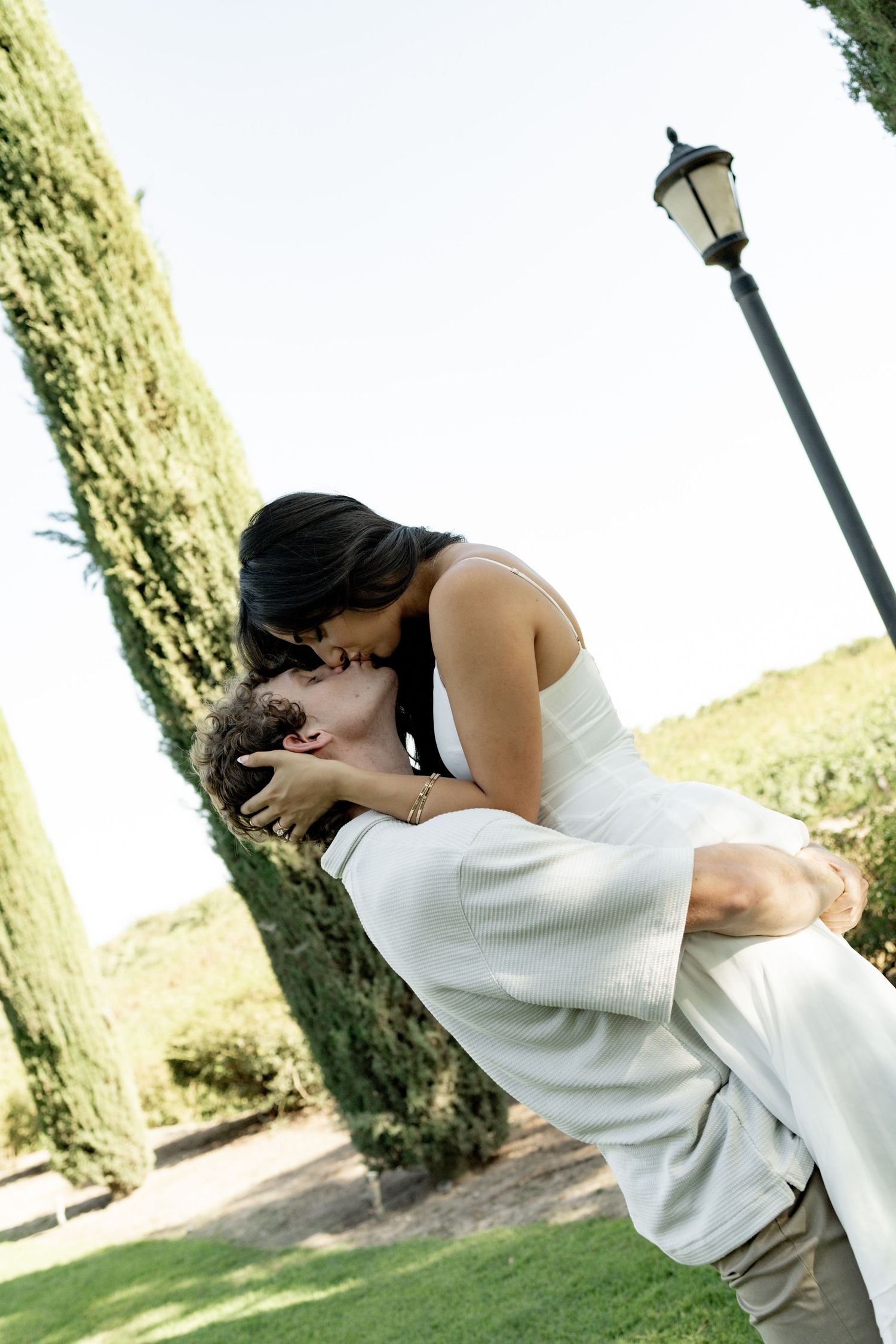 A romantic moment captured in a garden setting with a vintage lamppost.