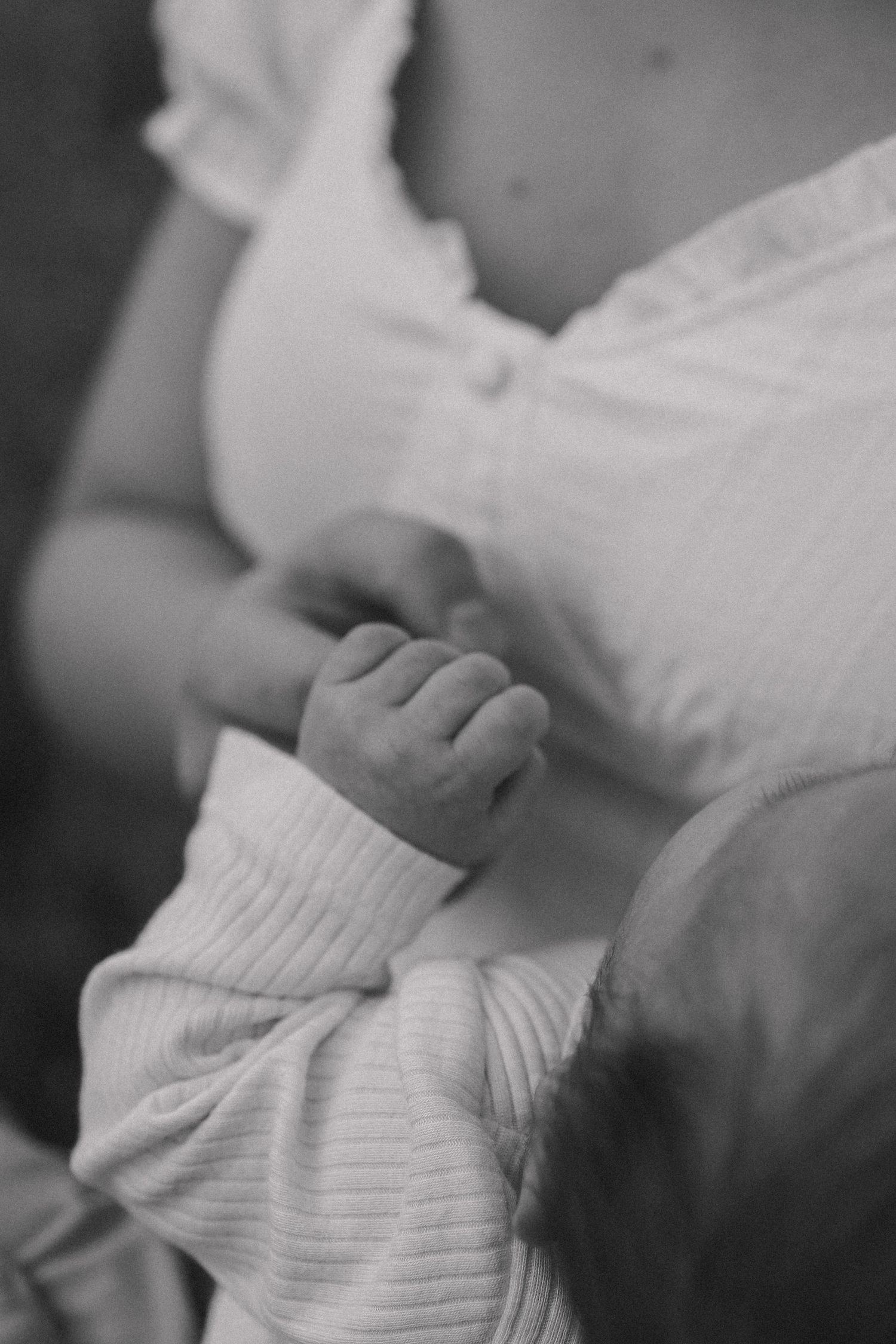 Black and white close-up images showing gentle hand gestures and tender moments in a sequence.