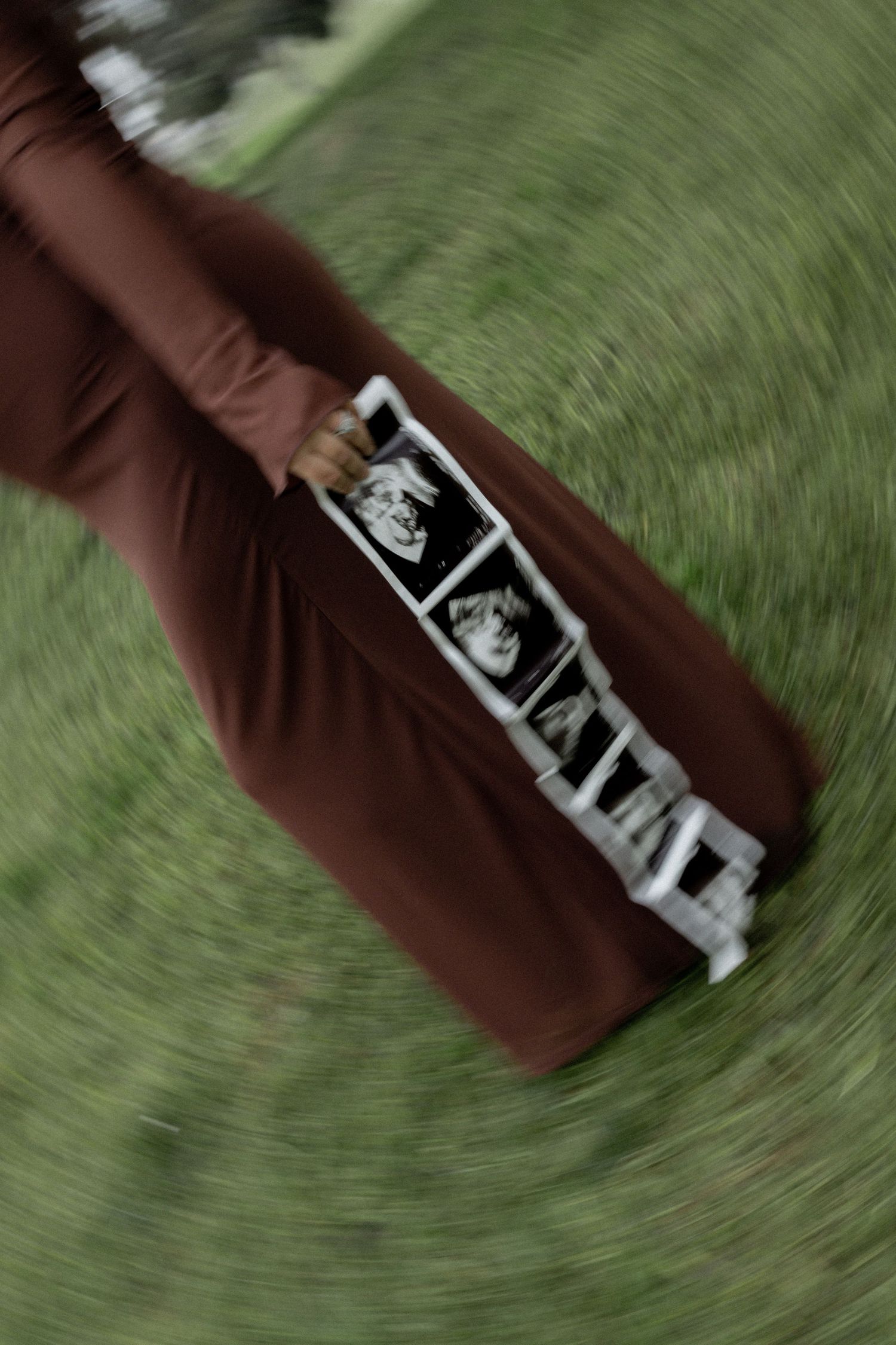 Blurred motion shot of a sonogram photo held against a green background.