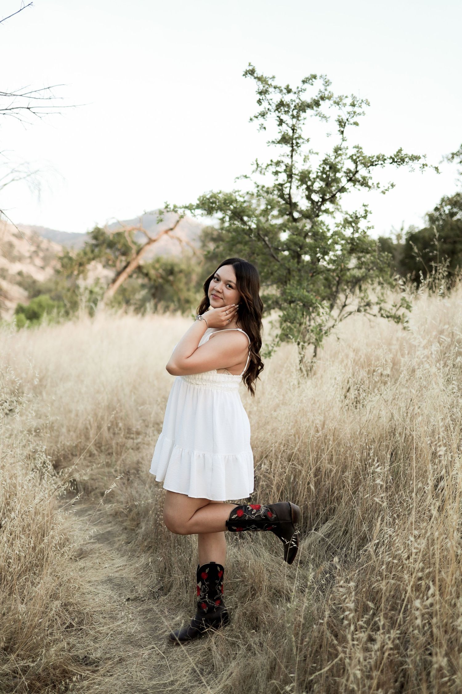 A series of artistic shots showing someone in a white dress posing in tall grass during golden hour.