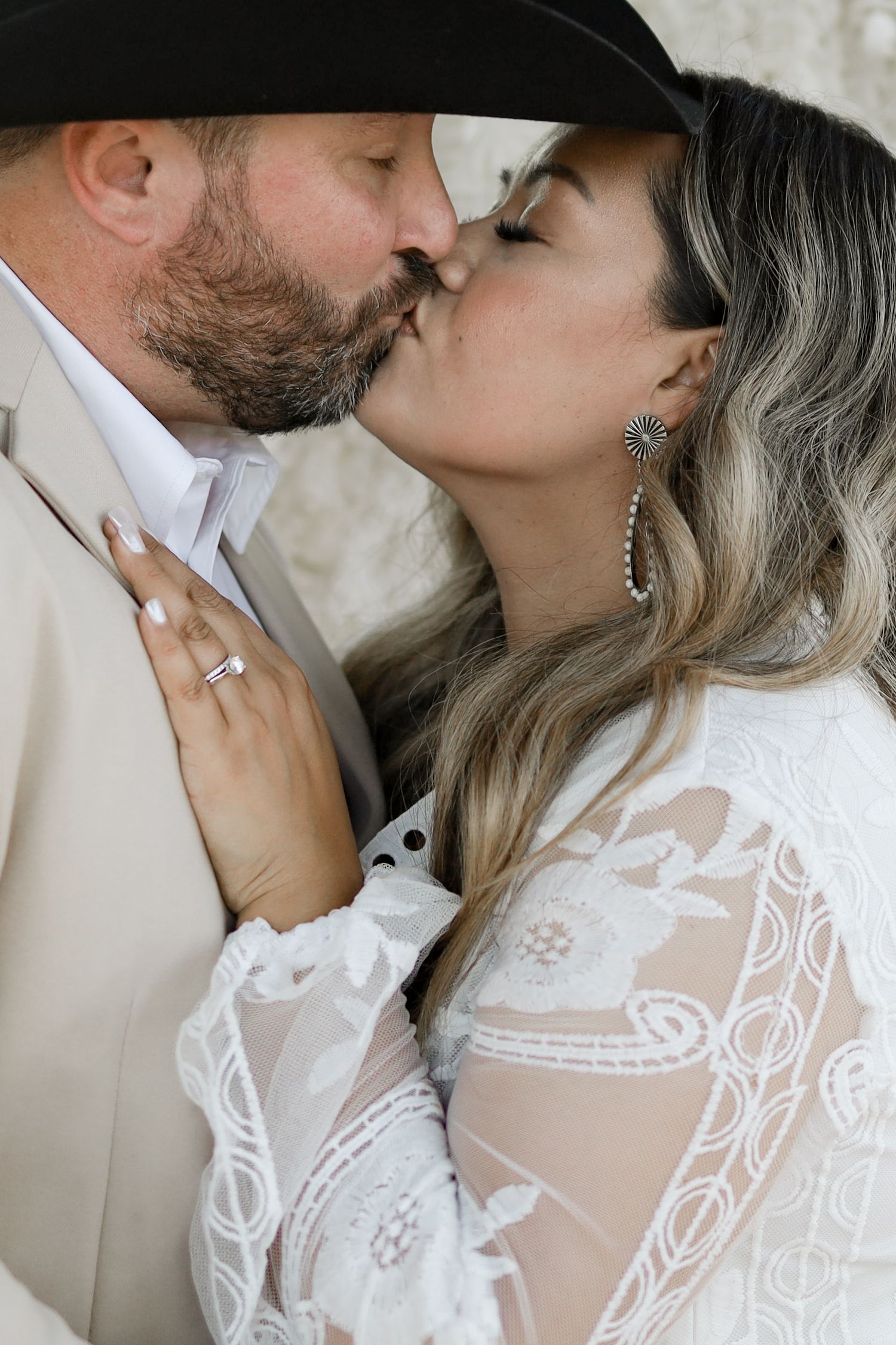Intimate close-up portraits of couple sharing tender moments in white formal attire.