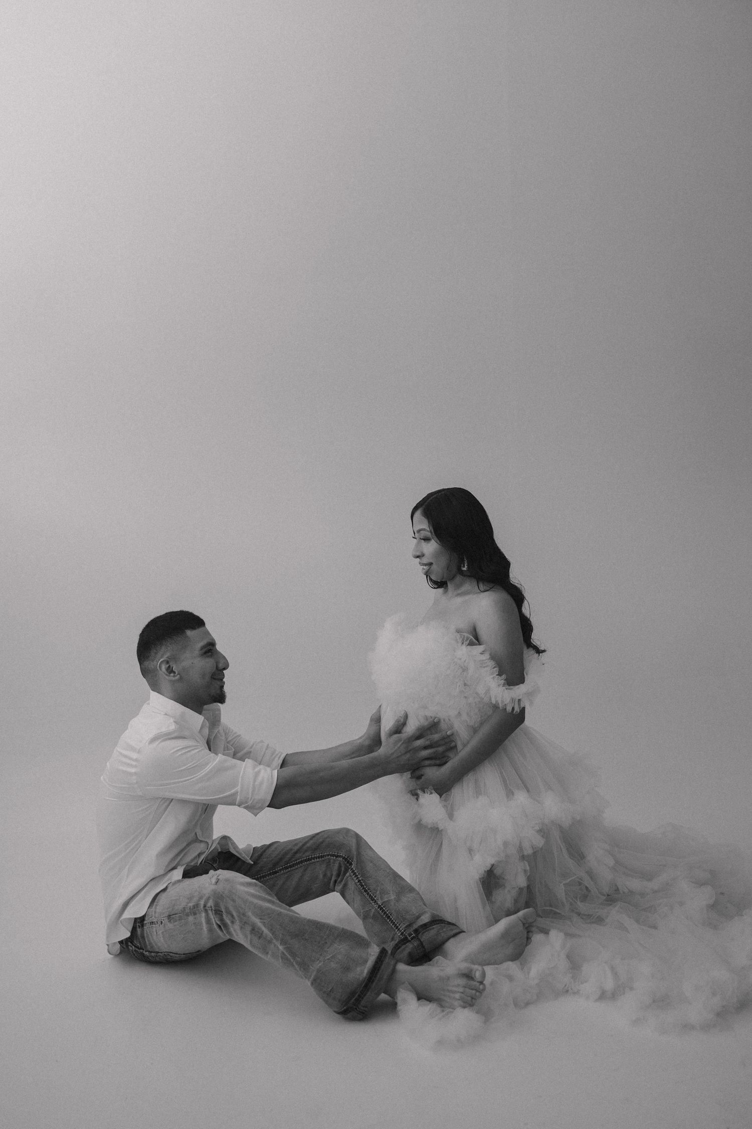Black and white artistic photo sequence showing a couple in white clothing creating ethereal movement with flowing fabric.