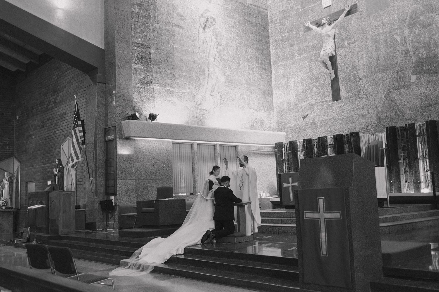 Interior of a church sanctuary with dramatic lighting and rows of wooden pews.