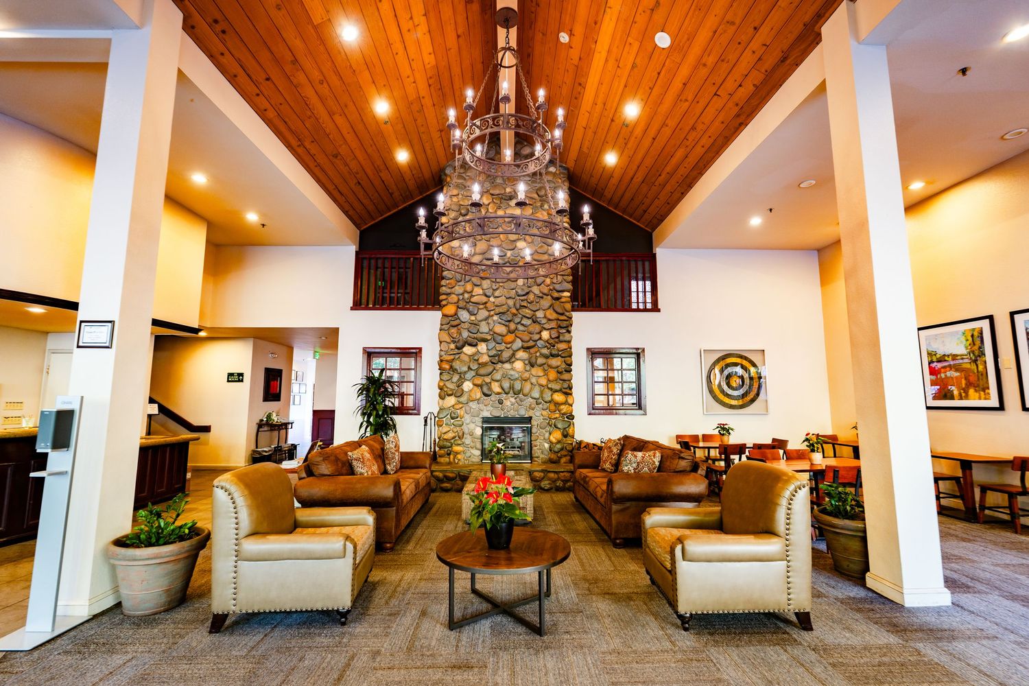 Elegant event space with vaulted wooden ceiling, chandeliers, and white columns creating an airy atmosphere at Forest Suits Resorts