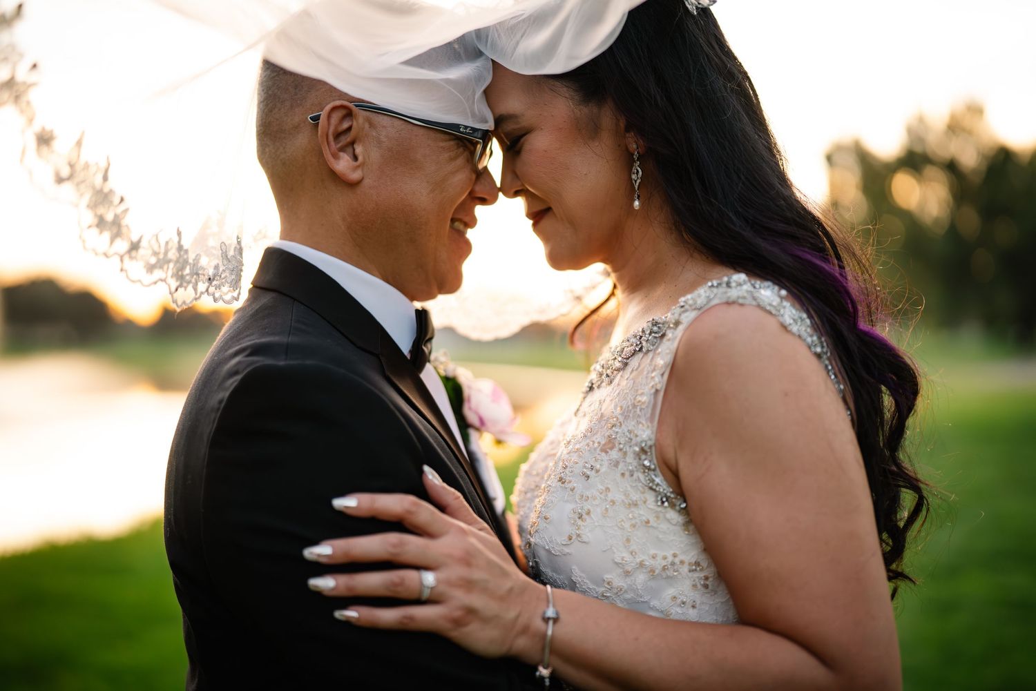 Romantic sunset portrait of newlyweds embracing in golden light.