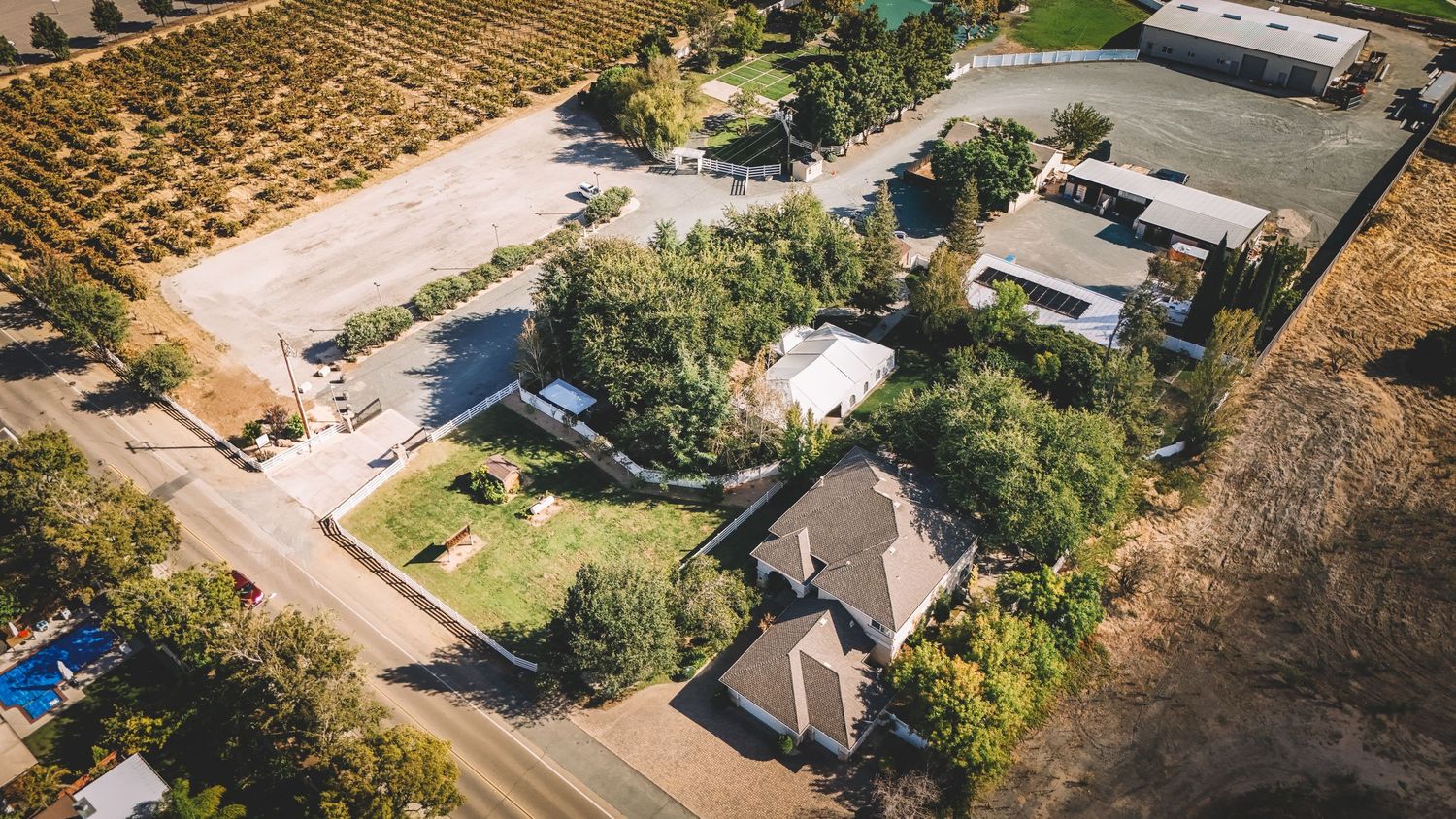 Aerial drone view of a rural property with buildings and landscaping La Grande Estates