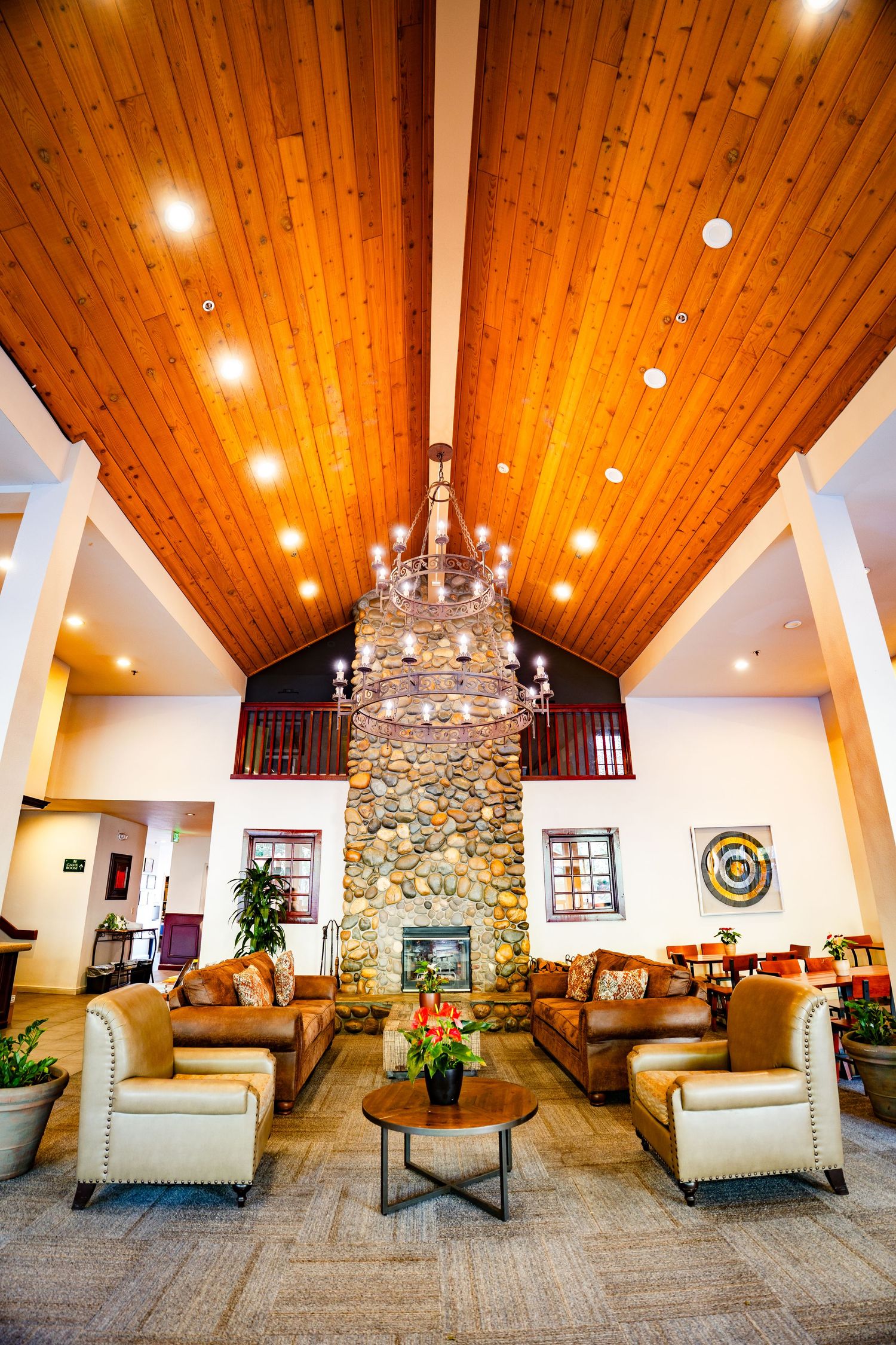 Luxurious lodge interior with stone fireplace, wood ceiling, and comfortable seating area at Forest Suits Resorts