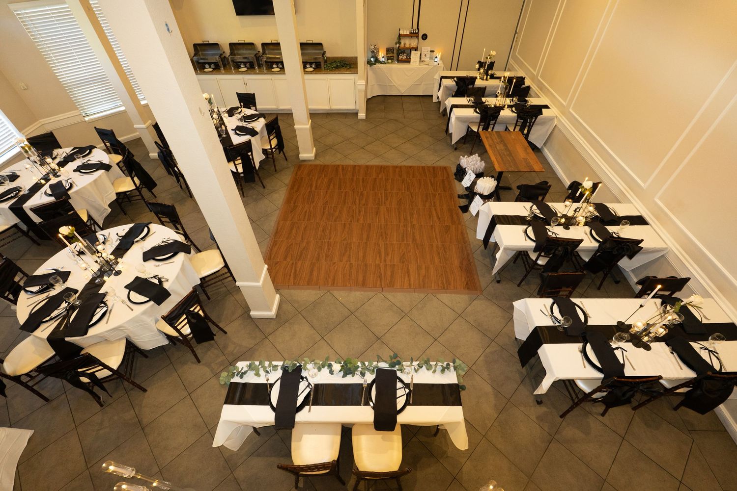 Large banquet hall setup with round tables and chairs arranged for a formal event at Forest Suits Resorts