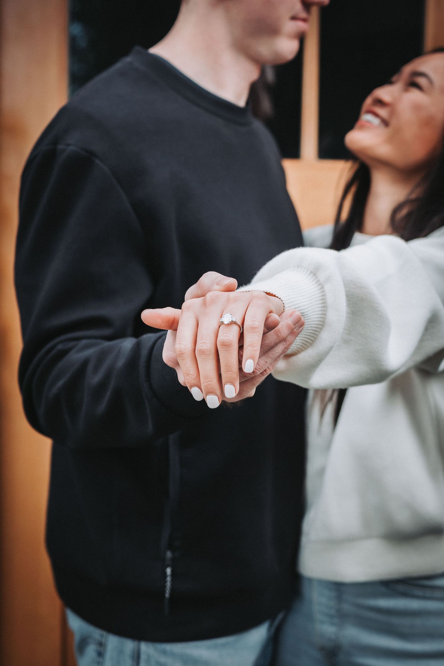 Romantic couple in black and white clothing share an intimate moment while holding hands.