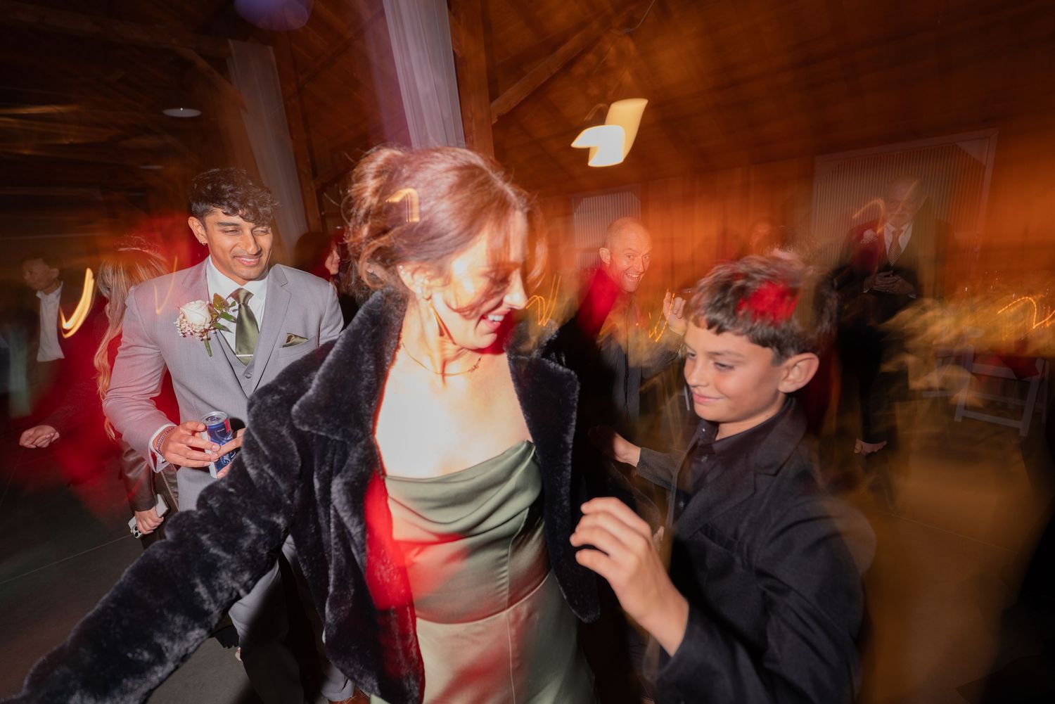 People dancing energetically at a festive indoor party, with motion blur capturing the lively atmosphere.