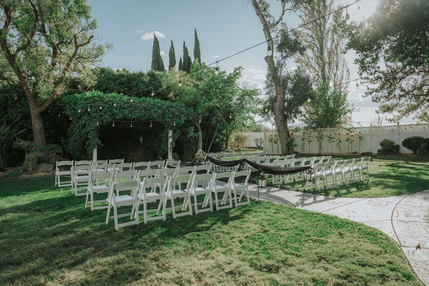 Outdoor wedding ceremony setup with white chairs on green lawn at La Grande Estates