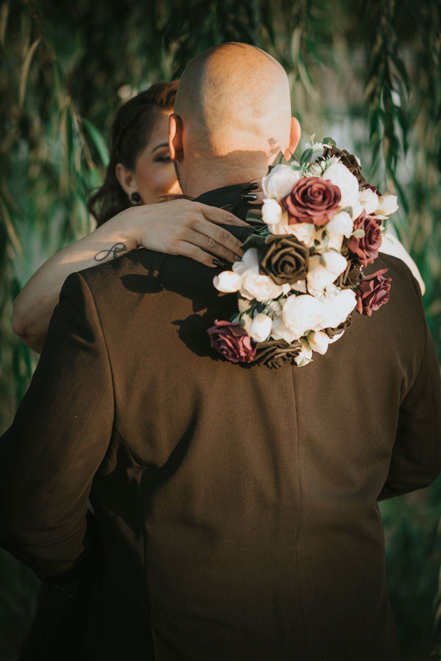 Beautiful floral arrangement with white and burgundy flowers adorns a brown jacket.