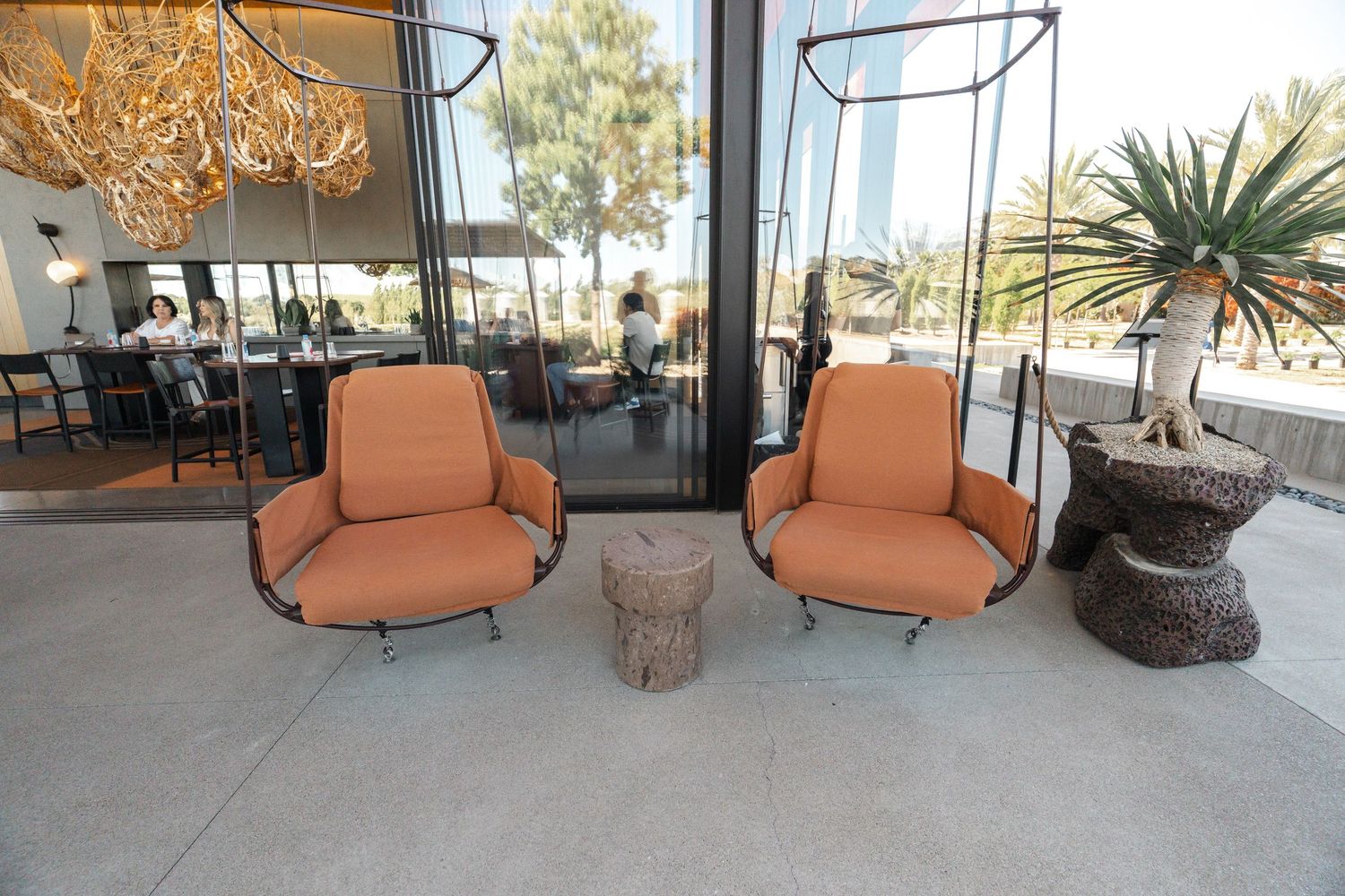 Stylish lounge area with orange armchairs and decorative lighting fixtures.