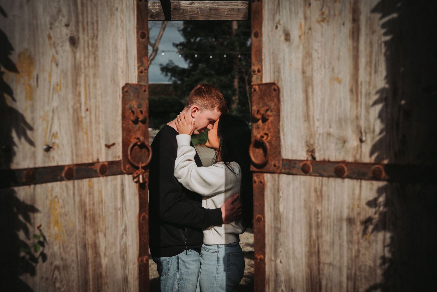 Intimate moments captured against weathered wooden barn walls.