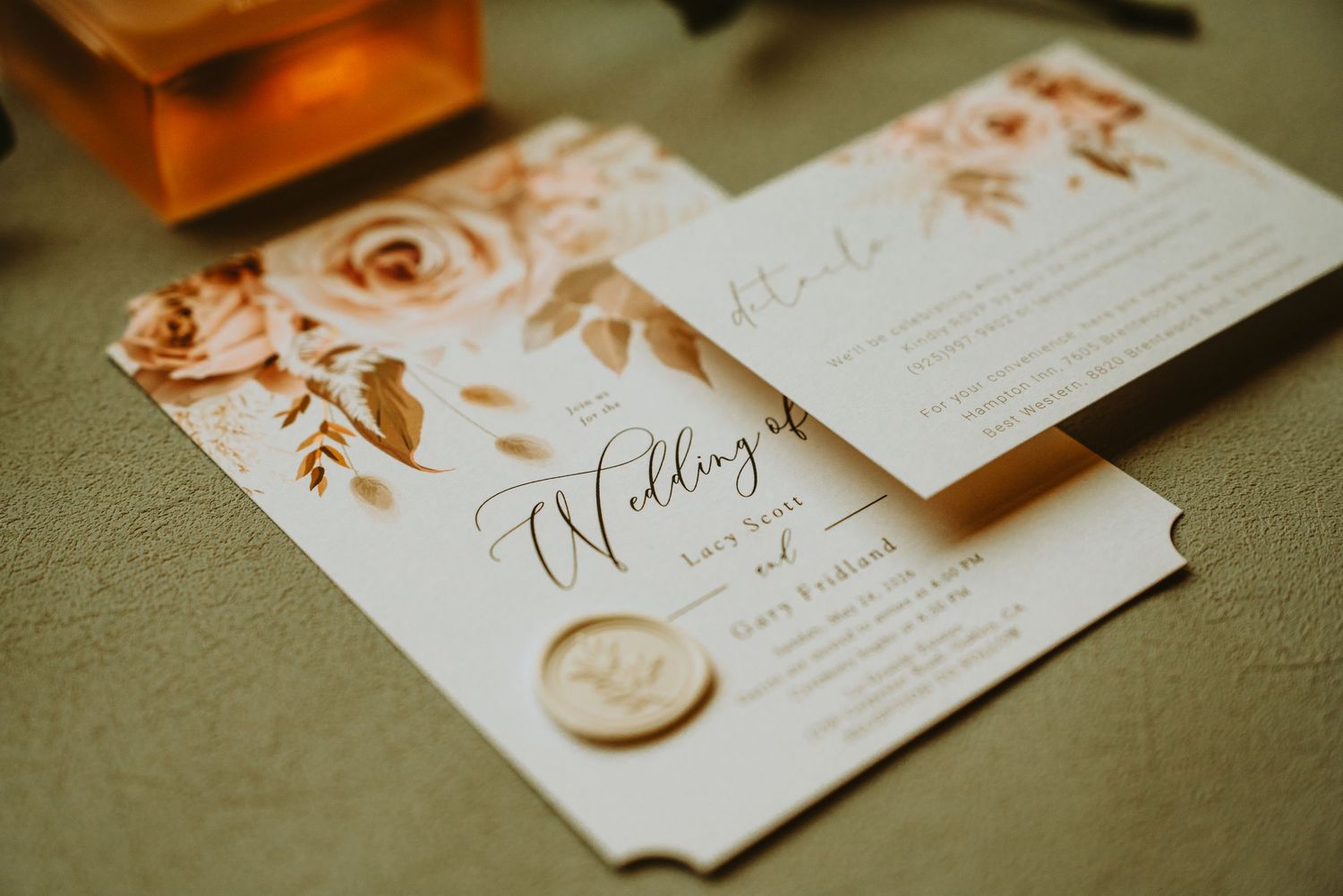 Elegant wedding invitation suite with blush floral watercolor design, gold wax seal, and calligraphy script on neutral background.