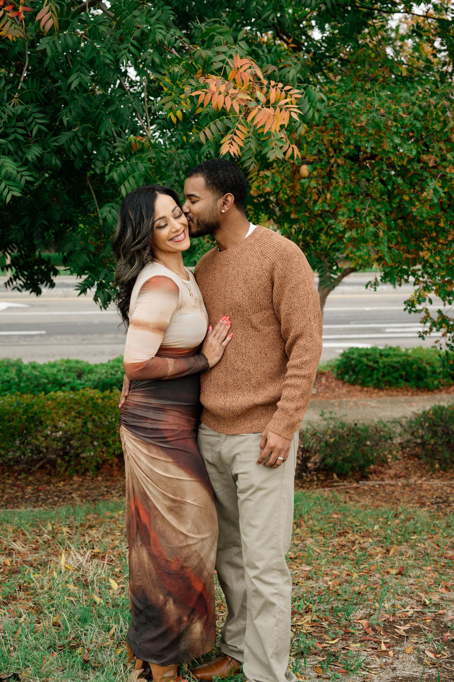 Intimate family portrait session in a park with autumn foliage.