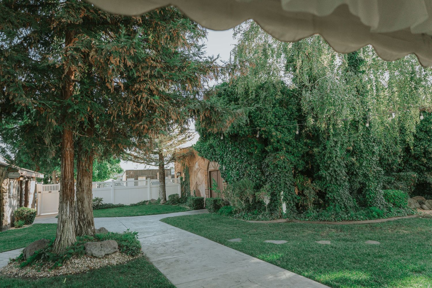 Tree-lined pathway through lush green garden setting at La Grande Estates
