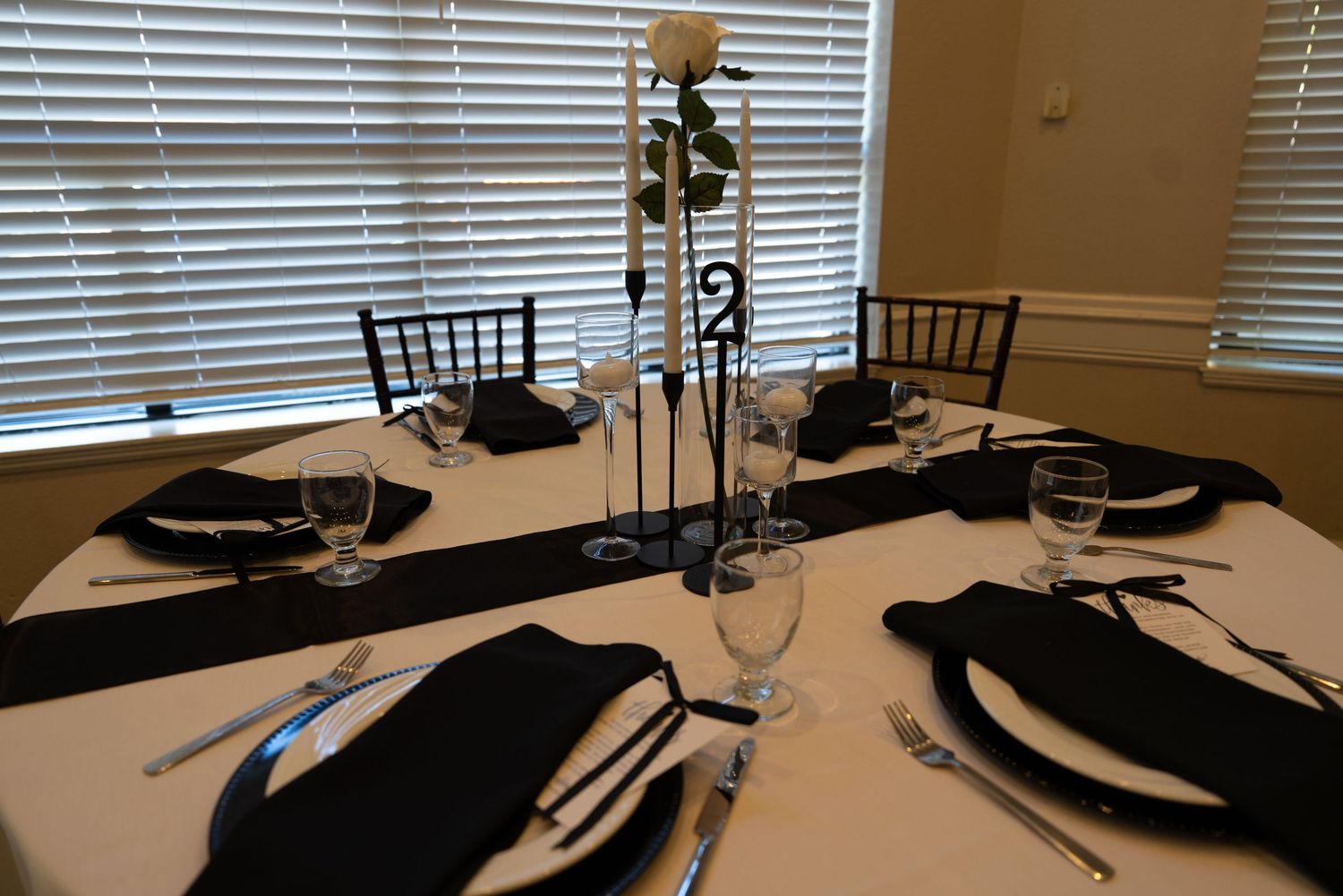 Formal table settings with black napkins and white tablecloths in an elegant dining room at Forest Suits Resorts