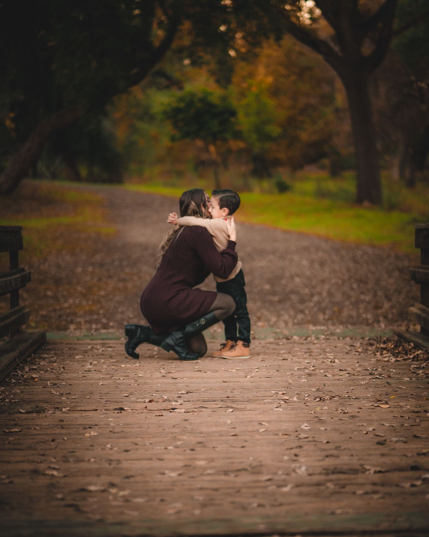 A touching moment captured on a leaf-covered pathway in autumn.
