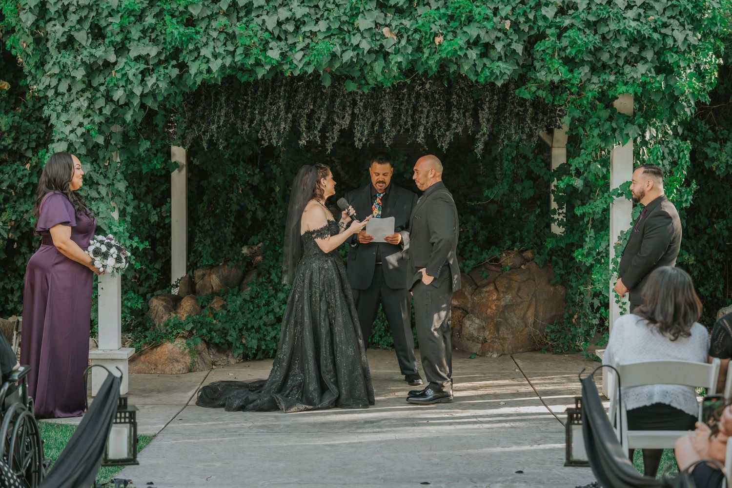 People in formal attire dance together at an outdoor garden venue during a celebration event at La Grande Estates