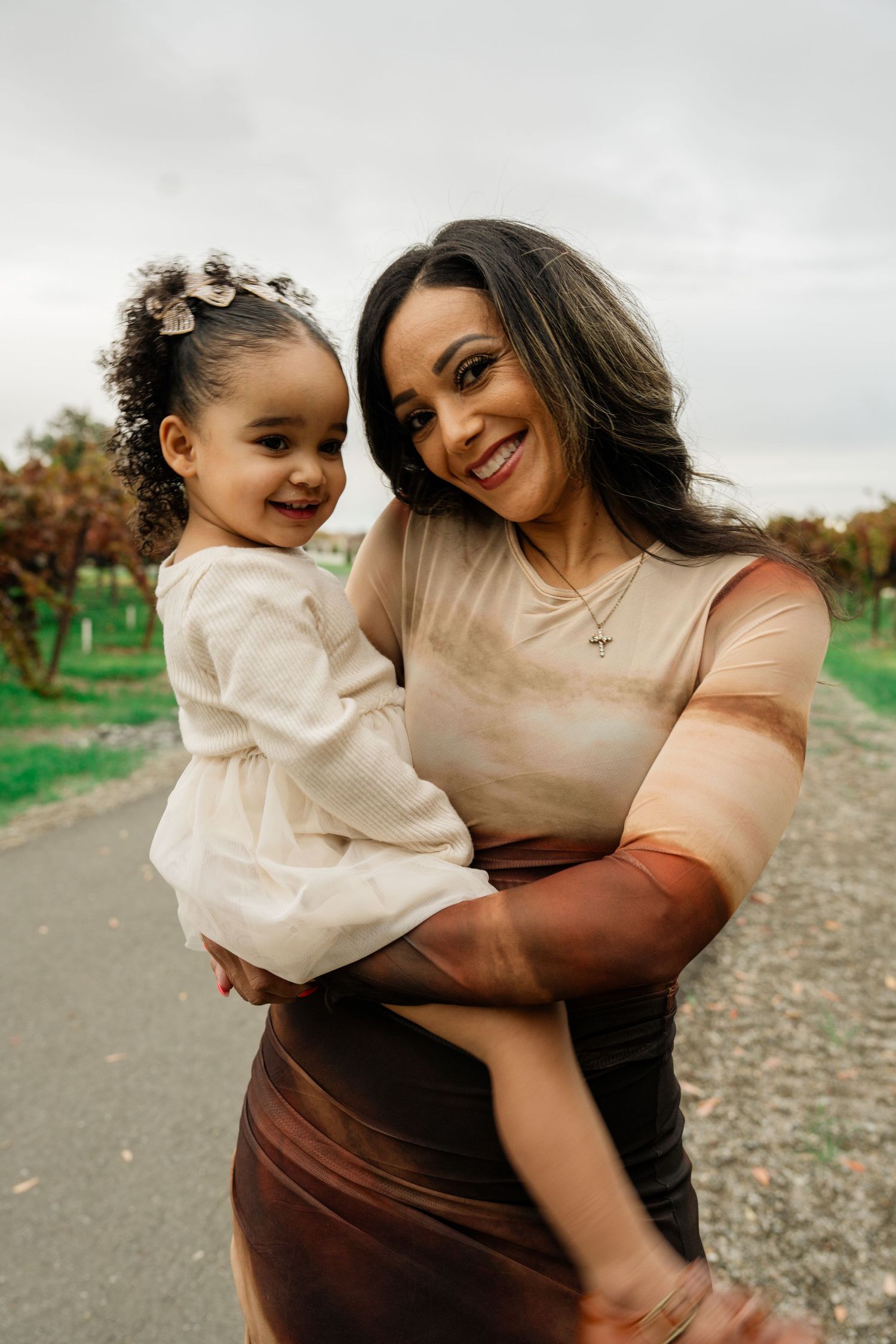 Mother and child share joyful moments together on a path during an autumn photoshoot.