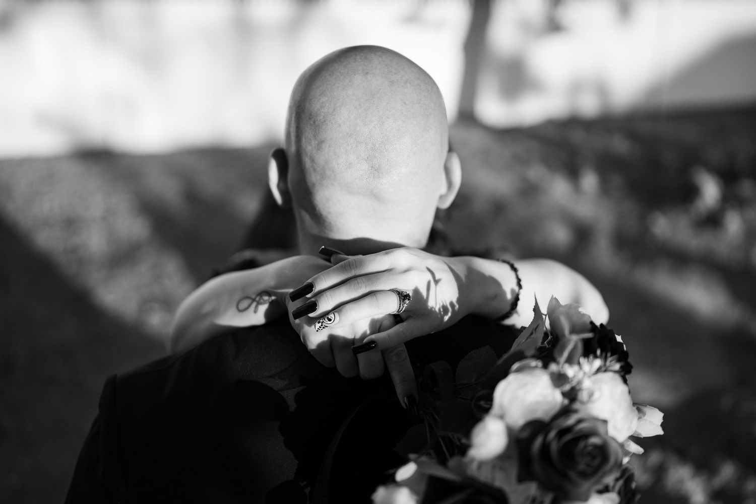 Wedding party members in black and white attire walk together outdoors.