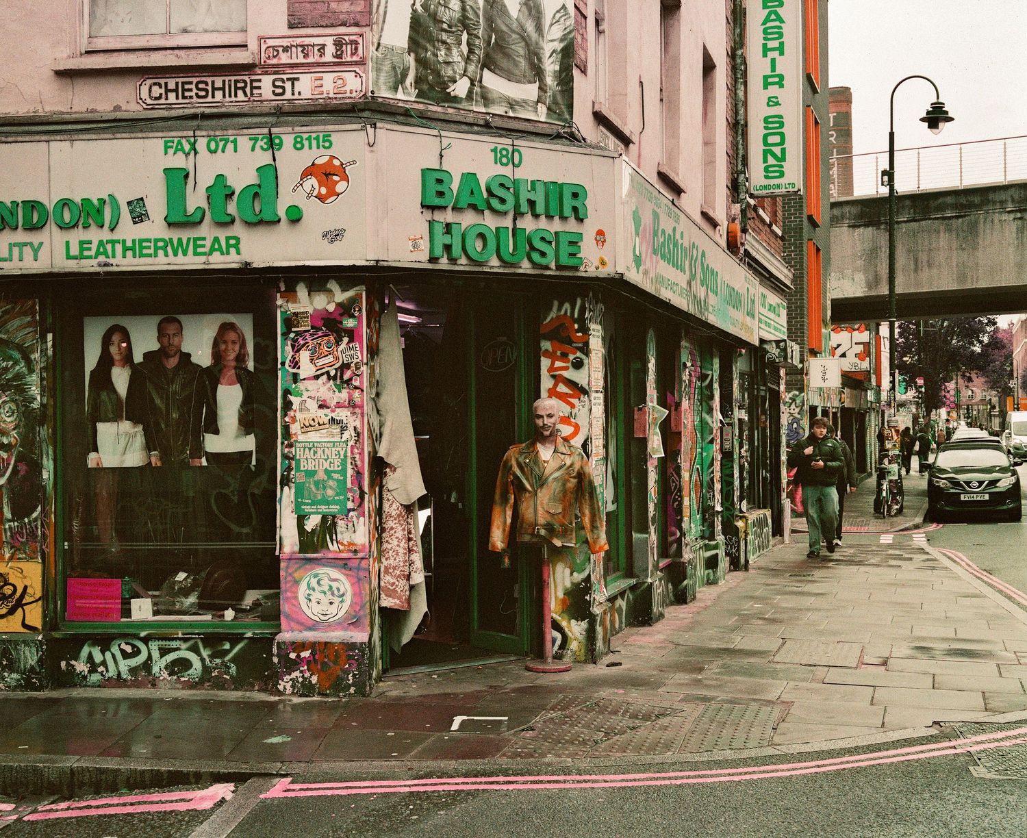 Colorful graffiti-covered shops on Cheshire Street corner in London's vibrant East End neighborhood.