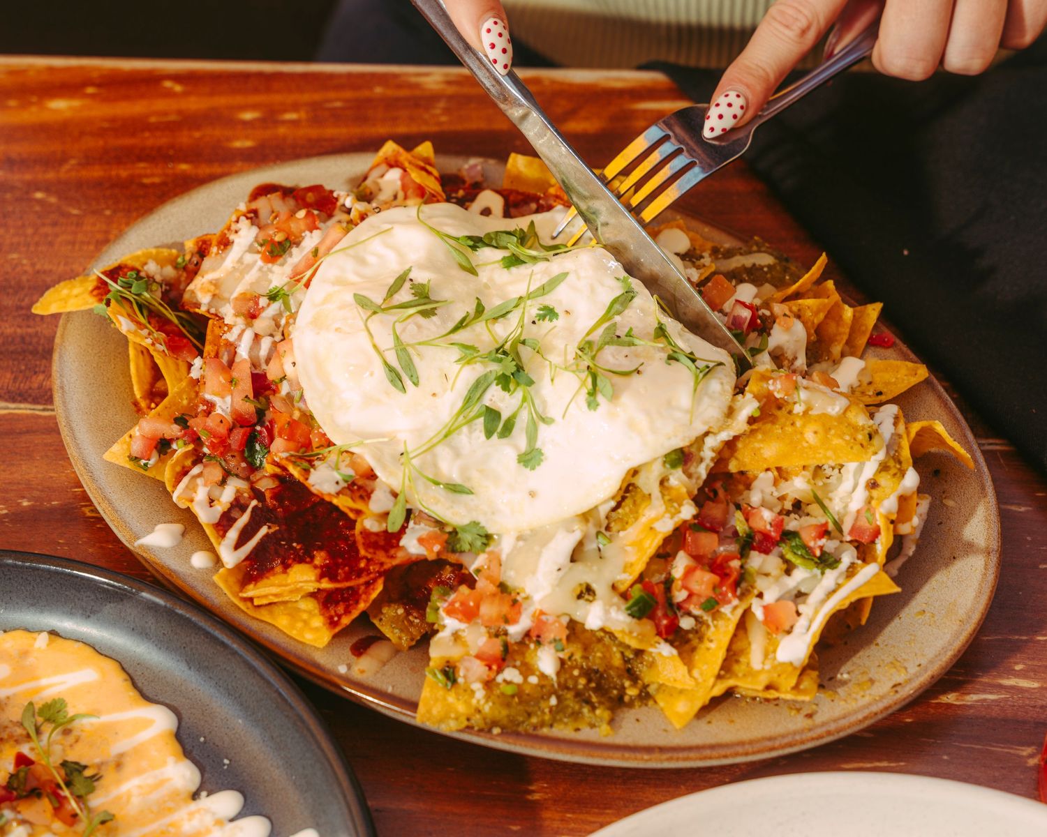 Loaded nachos topped with sour cream, salsa, and melted cheese on a plate.