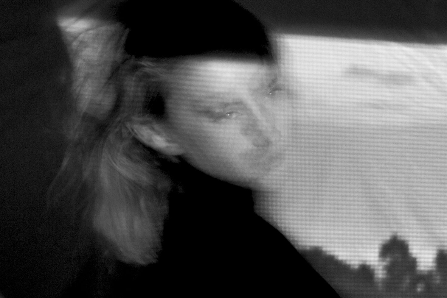 Abstract blurry black and white portrait of a person with long hair in motion.