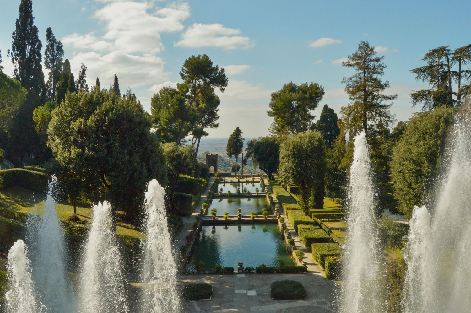Elegant fountains and manicured gardens at Villa d'Este in Tivoli, Italy, with cypress trees.