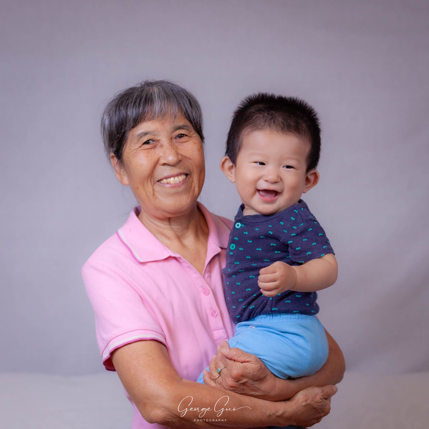 Grandmother and grandson smiling during a studio portrait session, captured by George Guo Photographer